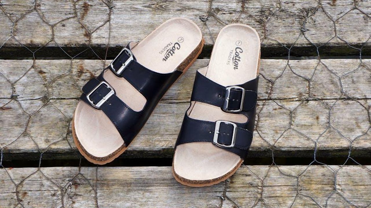 Sandali_Miller_Cloud_il_comfort_incontra_lo_stile_AMq9UxFQ21 - Confidenze24 Source: Mike Bird - pexels - Black leather buckle sandals on a wooden surface, perfect for casual summer fashion.
