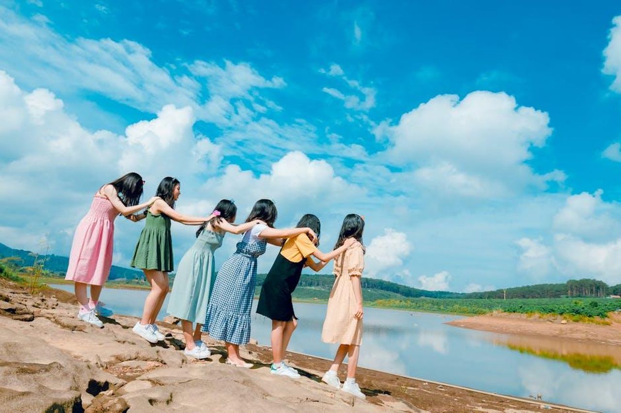 Sara_Carton_nega_i_rumor_su_una_relazione_con_Joey_2GHoVmWqyK - Confidenze24 Source: Chu Chup Hinh - pexels - Six young women holding hands near a lake, symbolizing friendship and unity.
