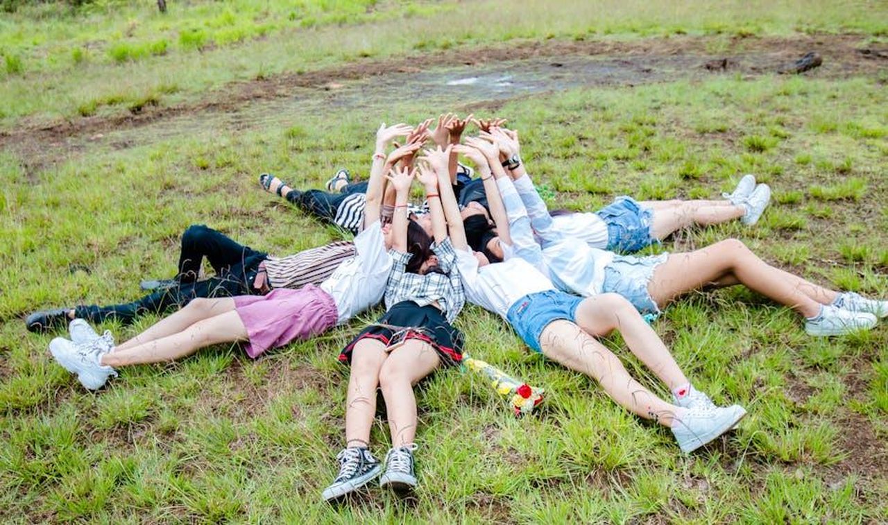 Sara_nega_le_voci_sul_suo_fidanzamento_con_Joey_r1273f0F4v - Confidenze24 Source: Chu Chup Hinh - pexels - Young adults lying in a circle on grass, arms raised in a sign of joy and friendship outdoors.