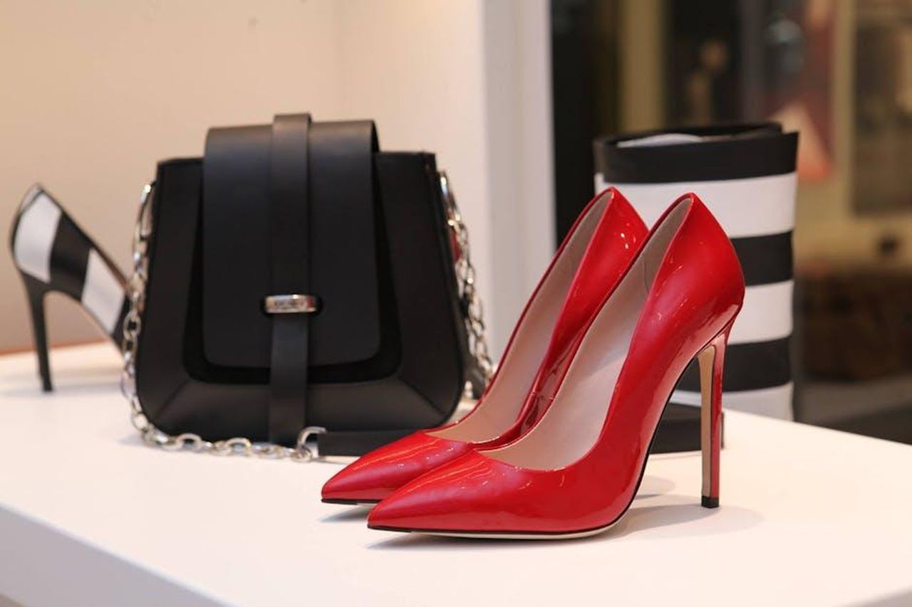 Scarpe_e_accessori_in_pelle_5DPe49xp8j - Confidenze24 Source: Alexandra Maria - pexels - Showcasing sleek red stilettos and a chic black handbag in a luxury boutique setting.