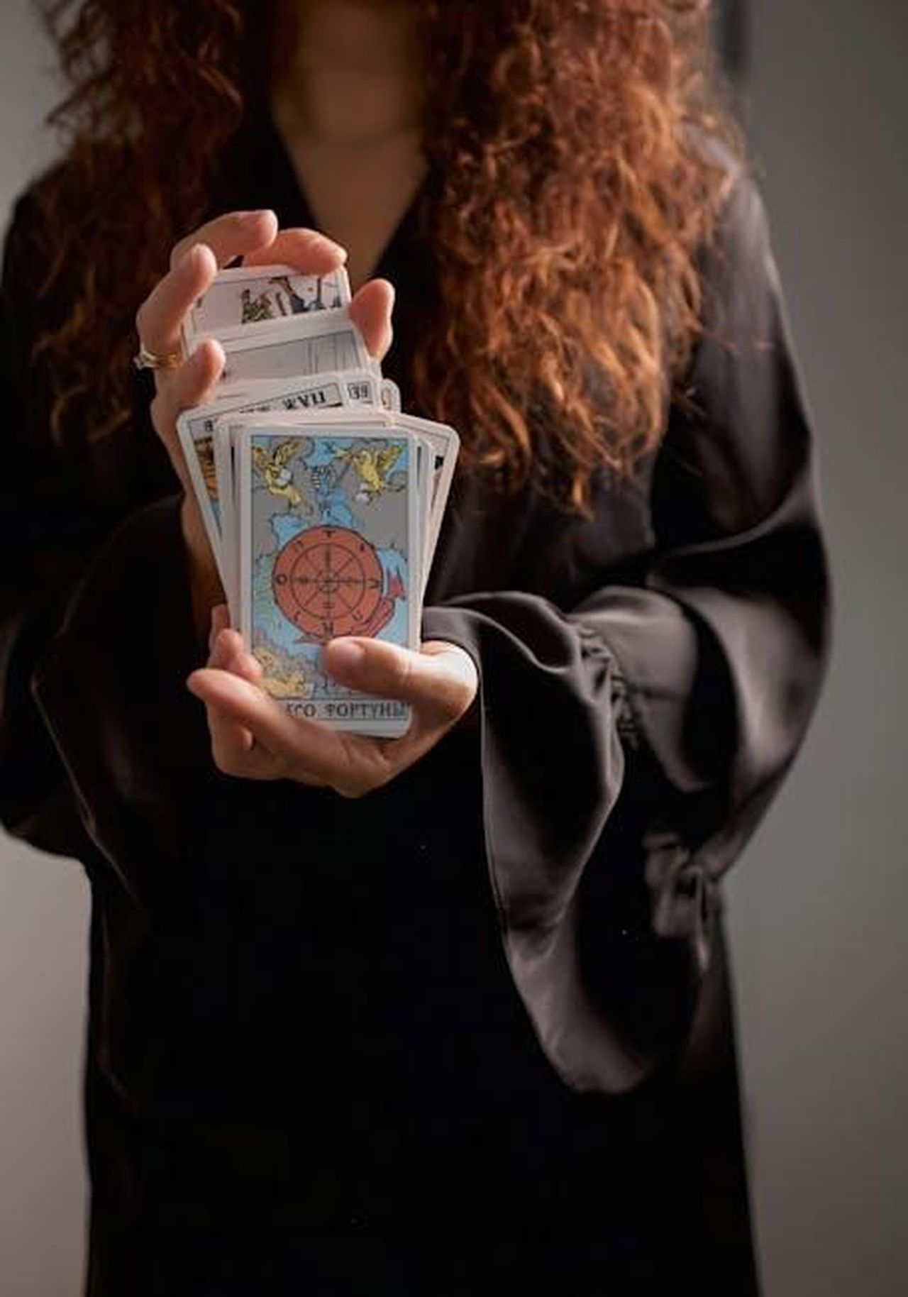 Scorpione_23_ottobre__21_novembre_3rvX9eT8NF - Confidenze24 Source: Mariia Sabadash - pexels - Close-up of a woman in black dress holding tarot cards, symbolizing spirituality and divination.