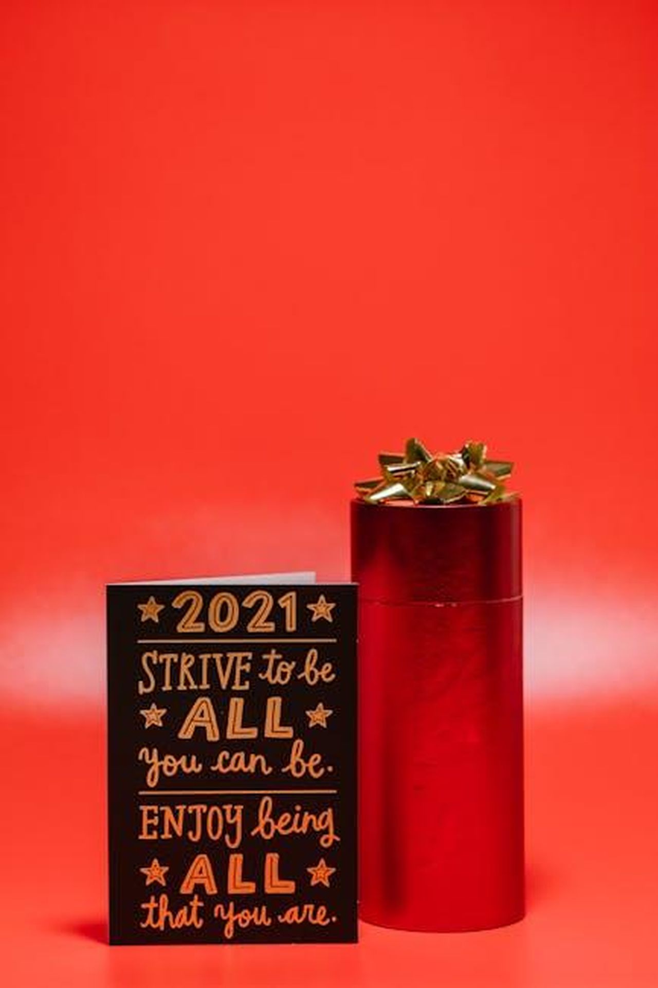 Sembri_favolosa_tB6MMTulyo - Confidenze24 Source: RDNE Stock project - pexels - Inspirational 2021 card and red gift box on vibrant background, perfect for celebrations.