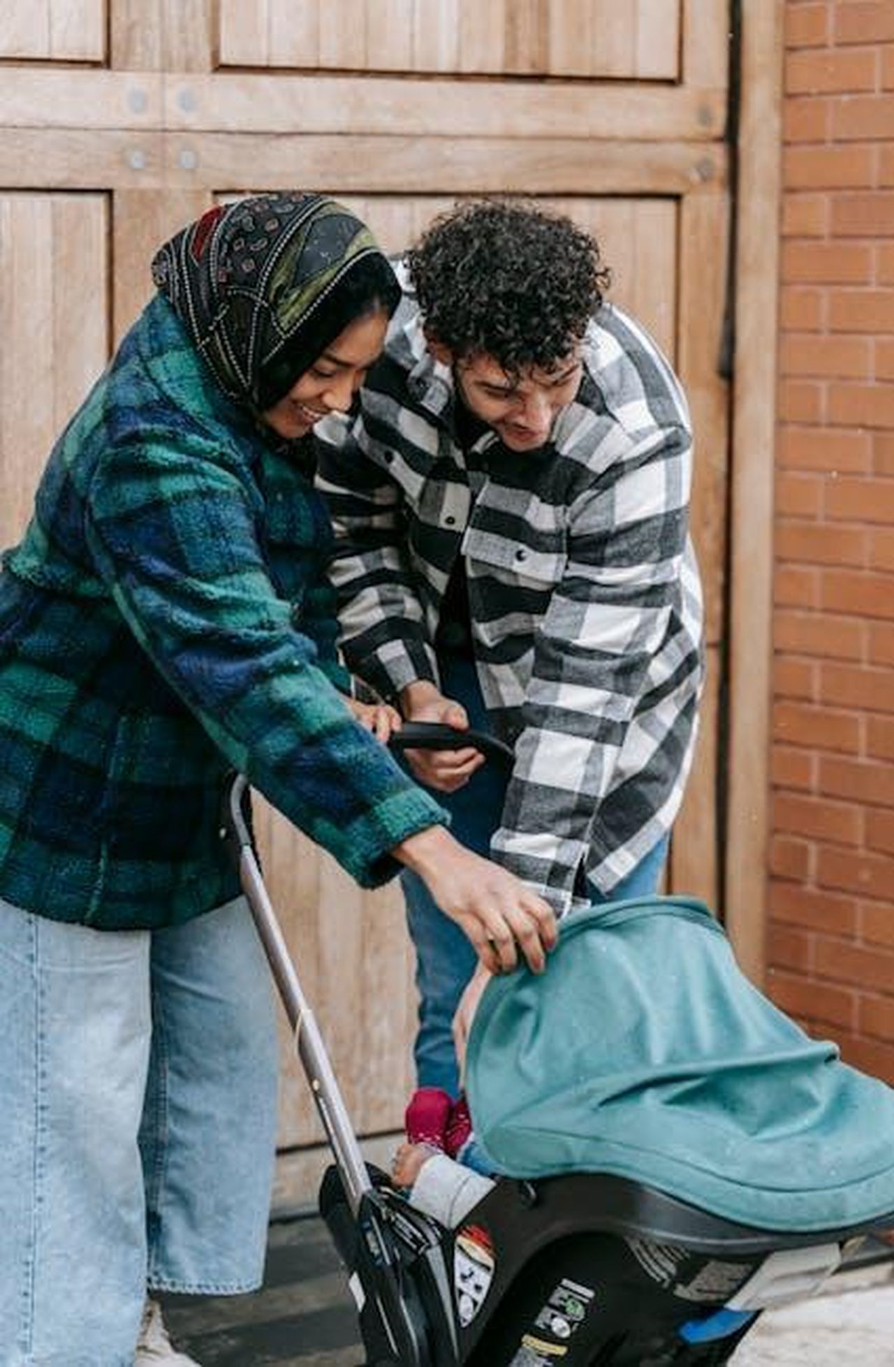 Separazione__e_ancora_vivere_insieme_38QXUsUCGi - Confidenze24 Source: William Fortunato - pexels - Positive African American mother and father standing near baby sitting in baby carriage on street in city near building