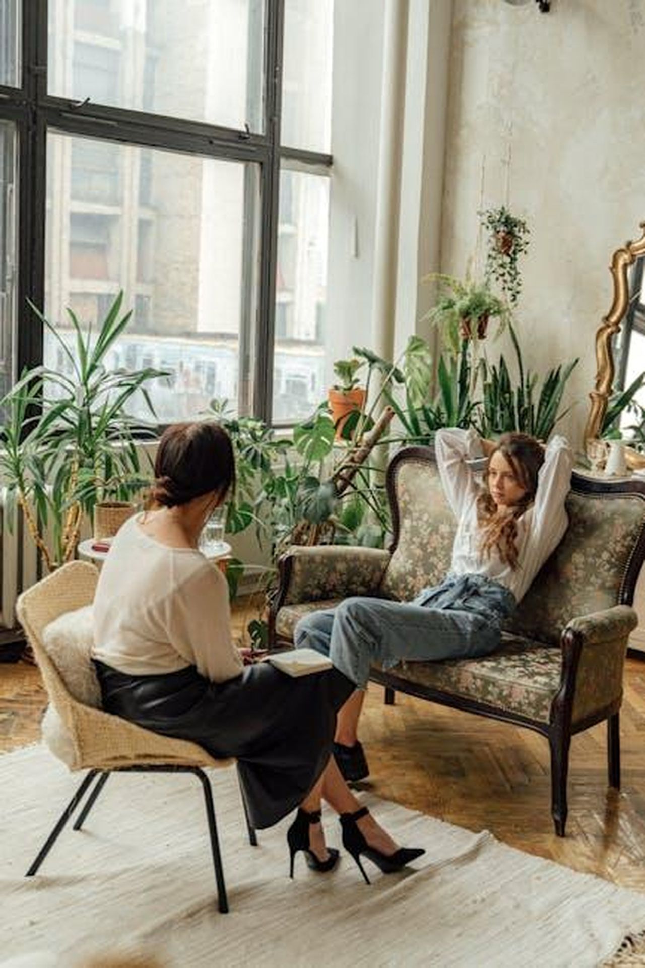 Separazione_professionale_di_Vogue_e_Spencer_H5oJ3EuRNY - Confidenze24 Source: Antoni Shkraba - pexels - Two women engaged in a counseling session in a cozy, plant-filled living room.