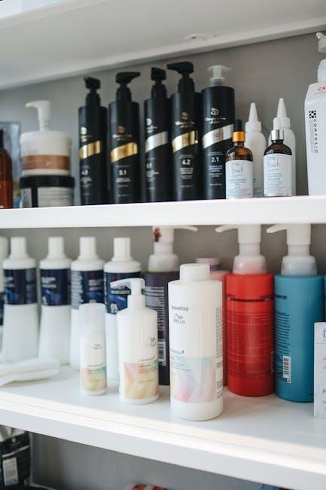Shampoo_Densifying_di_Oribe_recensioni_e_risultati_LoPv4bYisR - Confidenze24 Source: Polina Tankilevitch - pexels - Variety of shampoos and conditioners displayed neatly on a shelf, ideal for beauty and haircare themes.