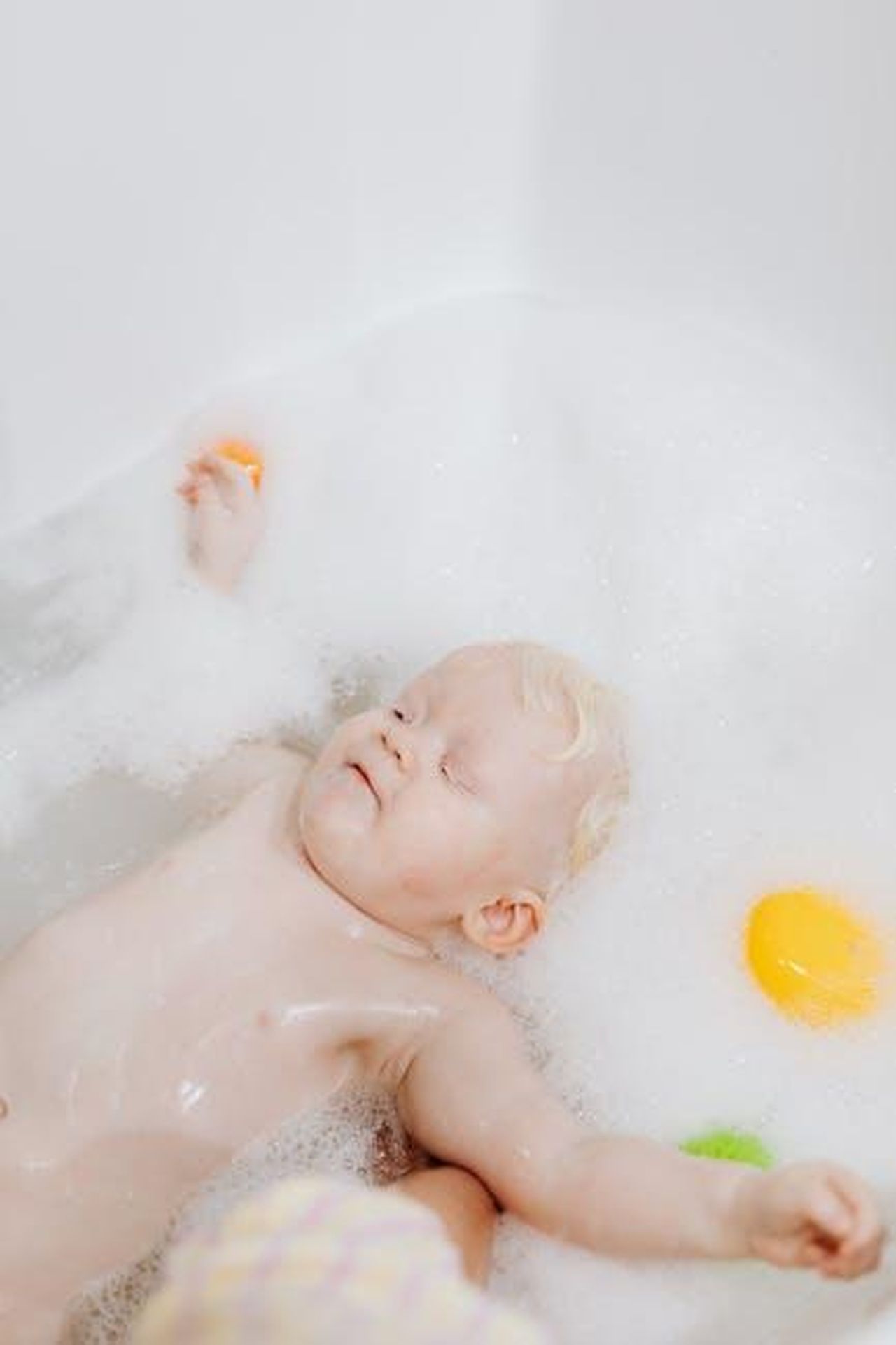 Sicurezza_prima_di_tutto_hcsttpaH6v - Confidenze24 Source: Photo By: Kaboompics.com - pexels - A baby enjoying a bubble bath with colorful bath toys, conveying a sense of relaxation and playfulness.