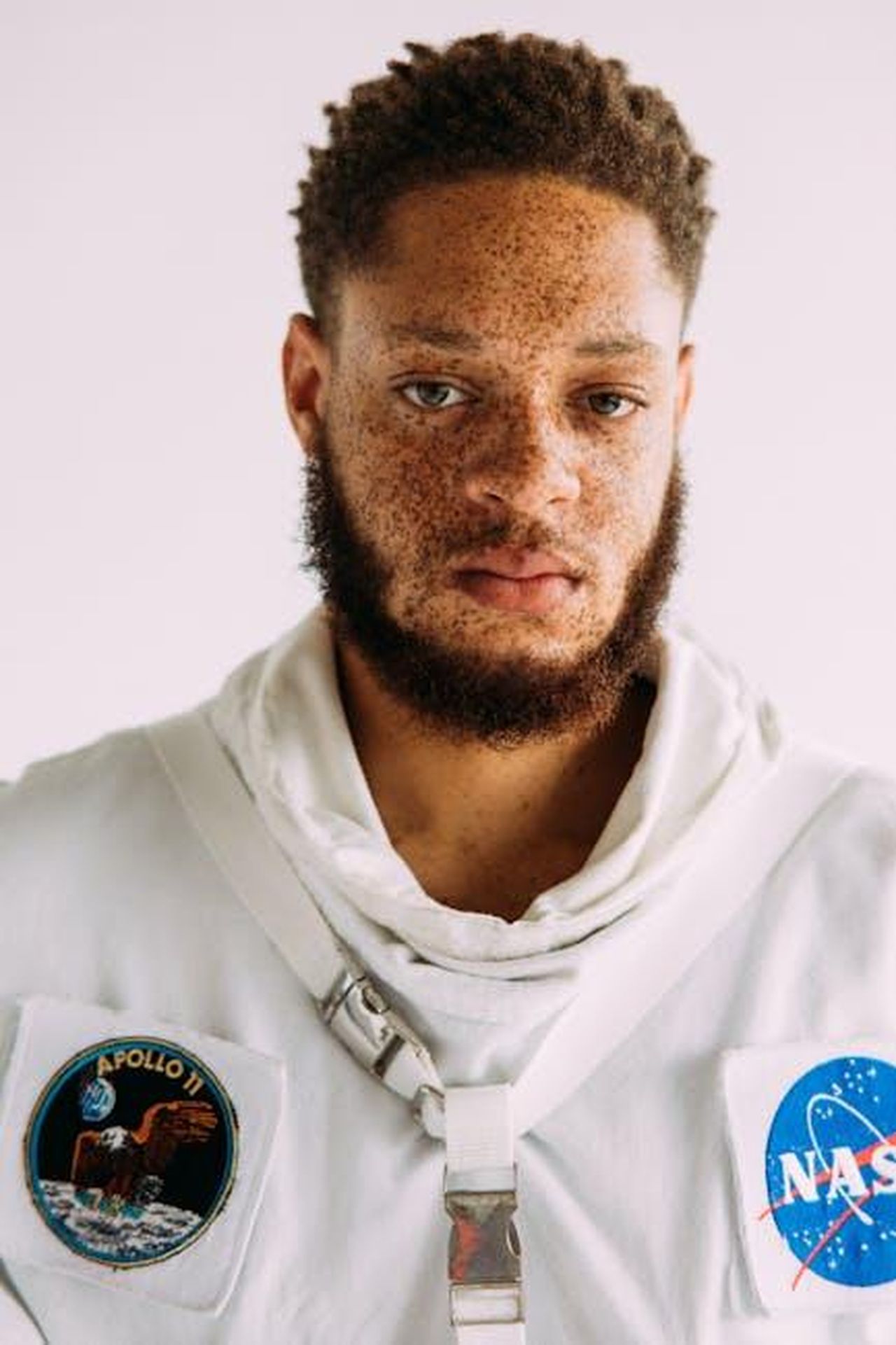 Simbolismo_del_mission_patch_8dDEnZTzeO - Confidenze24 Source: T Leish - pexels - Man with freckles in NASA themed astronaut suit, studio portrait.