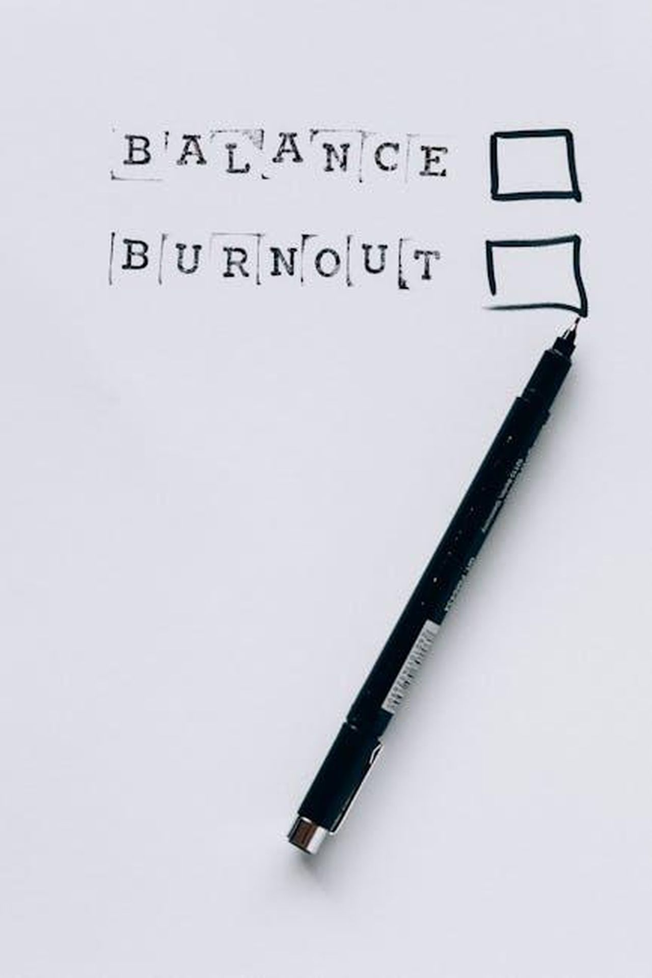 Sindrome_dellimpostore_a_Yale_6Dx51Qzh5x - Confidenze24 Source: Nataliya Vaitkevich - pexels - A pen beside checkboxes labeled 'Balance' and 'Burnout'. Choose wisely.