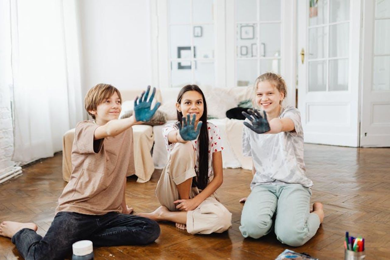 Sono_ancora_disordinati_gOP7bfgUJS - Confidenze24 Source: Photo By: Kaboompics.com - pexels - Three smiling teenagers showing painted hands enjoying a creative activity indoors.