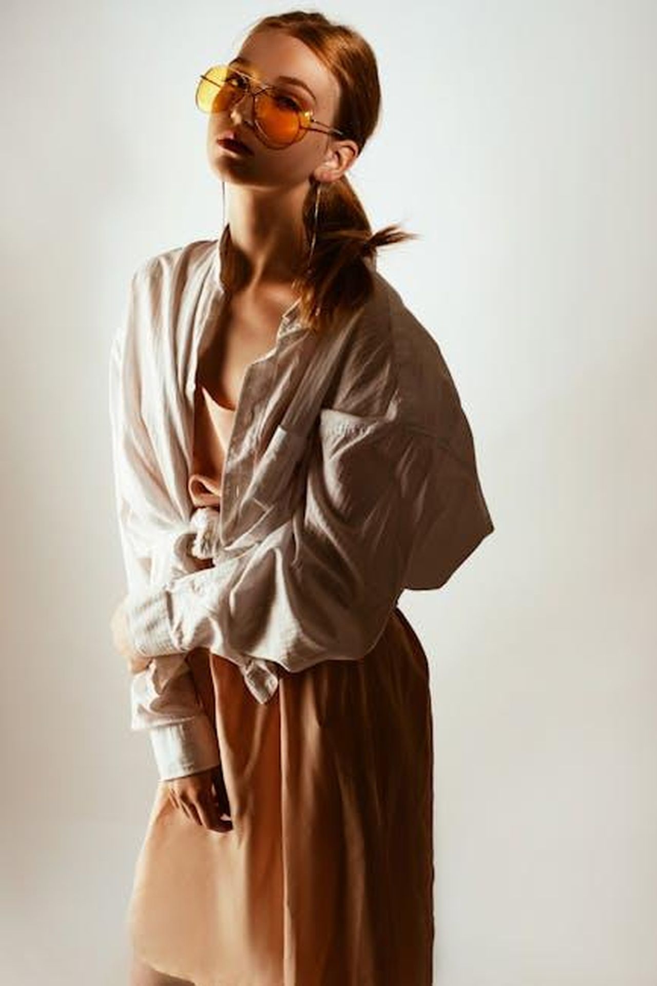 Sono_o_una_bomba_sexy_o_un_hobo_dociDPaKTN - Confidenze24 Source: Konstantin Mishchenko - pexels - Trendy woman posing in oversized shirt and sunglasses, exuding modern fashion style.