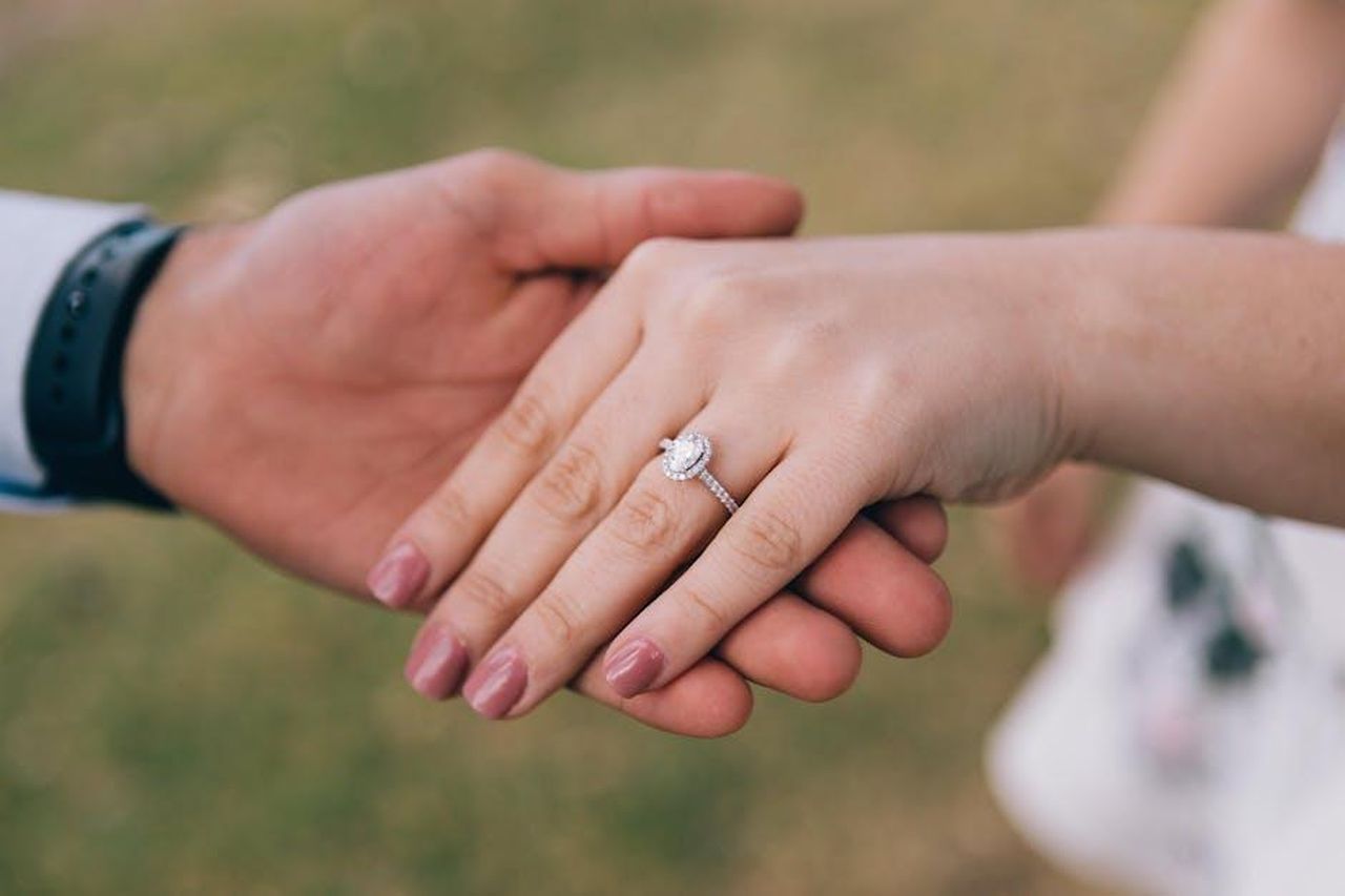 Stephen_Fry_parla_della_proposta_a_Elliott_fqiMTGwyg6 - Confidenze24 Source: Elegant Images - pexels - Romantic gesture of couple holding hands, showcasing a diamond engagement ring.