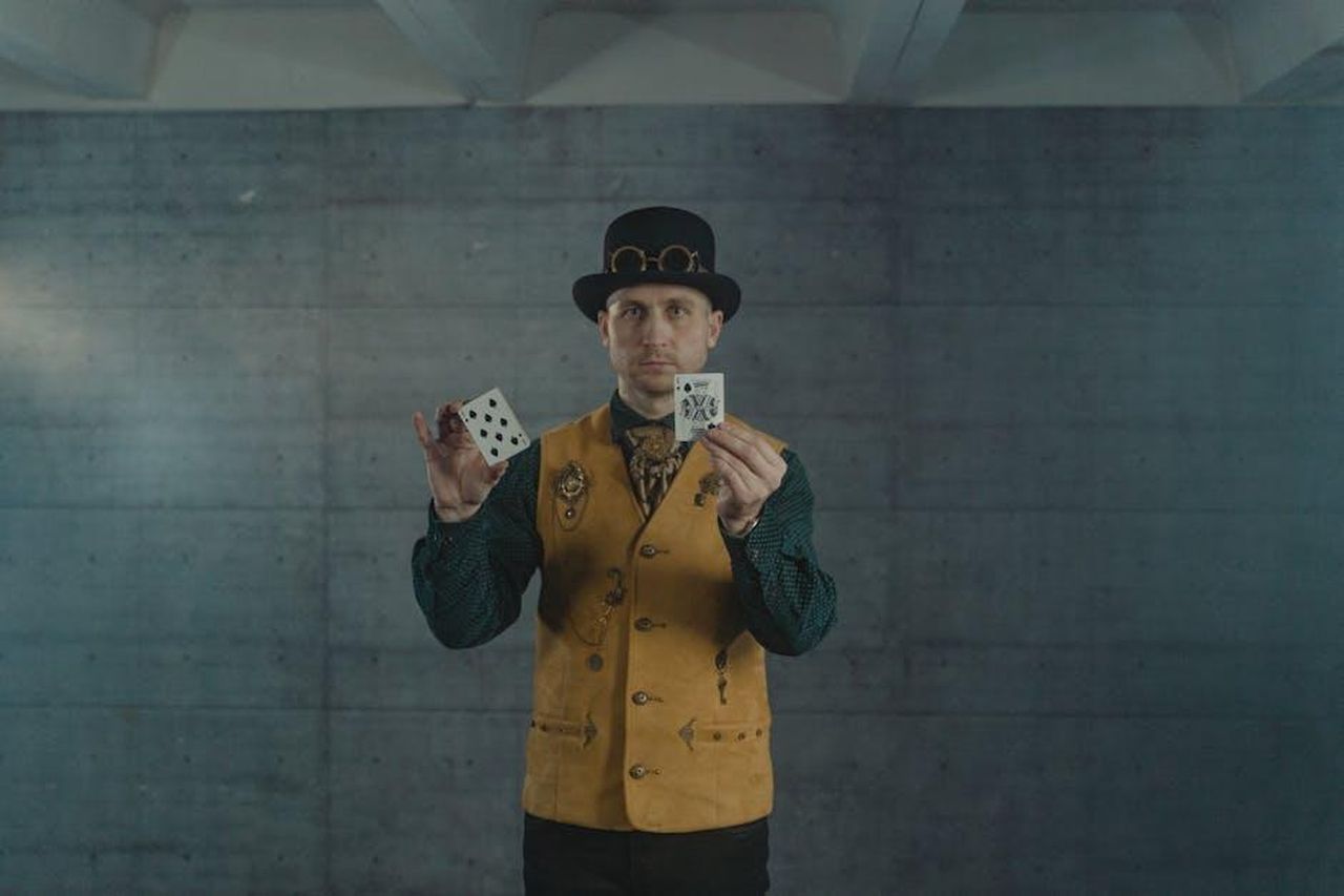 Stephen_su_You_Bet_MRASxdcdc9 - Confidenze24 Source: Tima Miroshnichenko - pexels - A man in steampunk attire showcasing card tricks indoors.