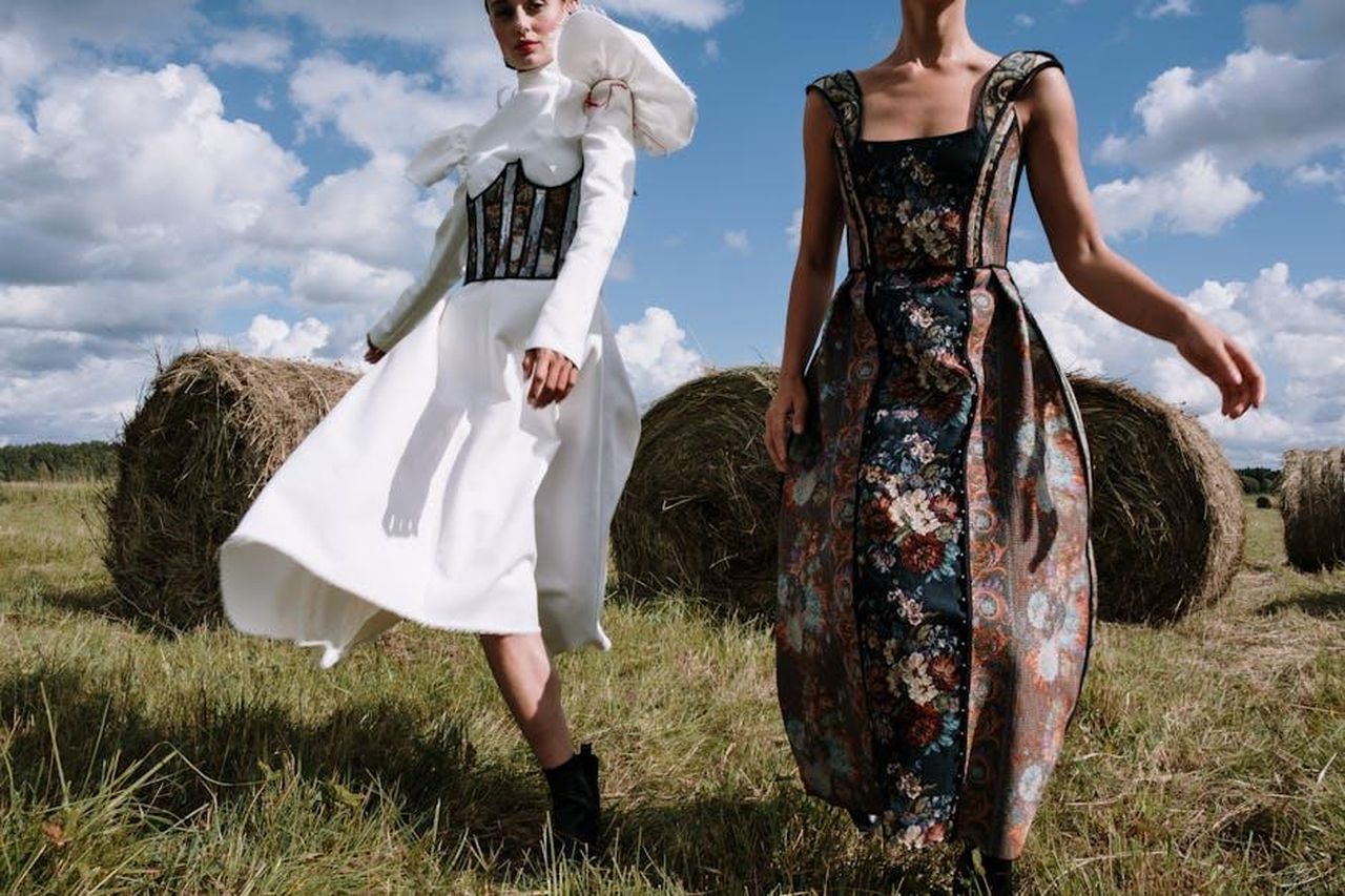 Stunning_48Pgy0mp3F - Confidenze24 Source: cottonbro studio - pexels - Stylish models in elegant dresses posing with hay bales under a bright sky.