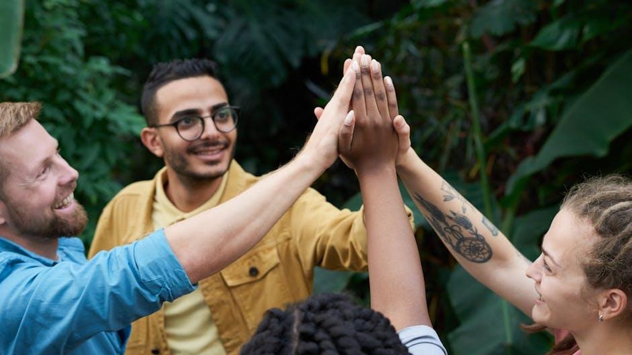 Supporto_per_London_Hughes_J8FoyUsL8H - Confidenze24 Source: fauxels - pexels - A joyful group of friends high-fiving outdoors, symbolizing teamwork and camaraderie.