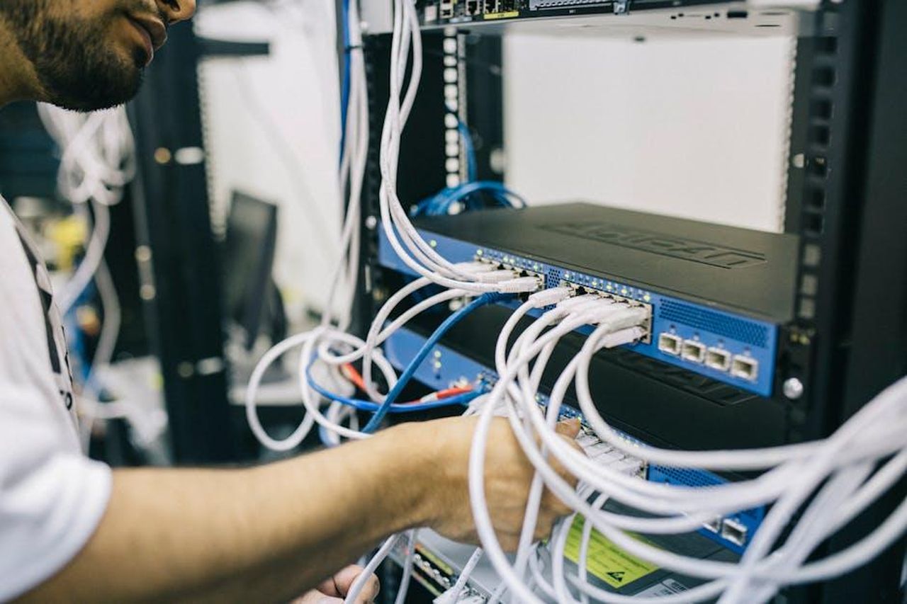 Supporto_ricevuto_da_amici_e_fan_sGTolQYoVV - Confidenze24 Source: Field Engineer - pexels - An IT professional configuring network cables in a server rack, focusing on Ethernet connections.