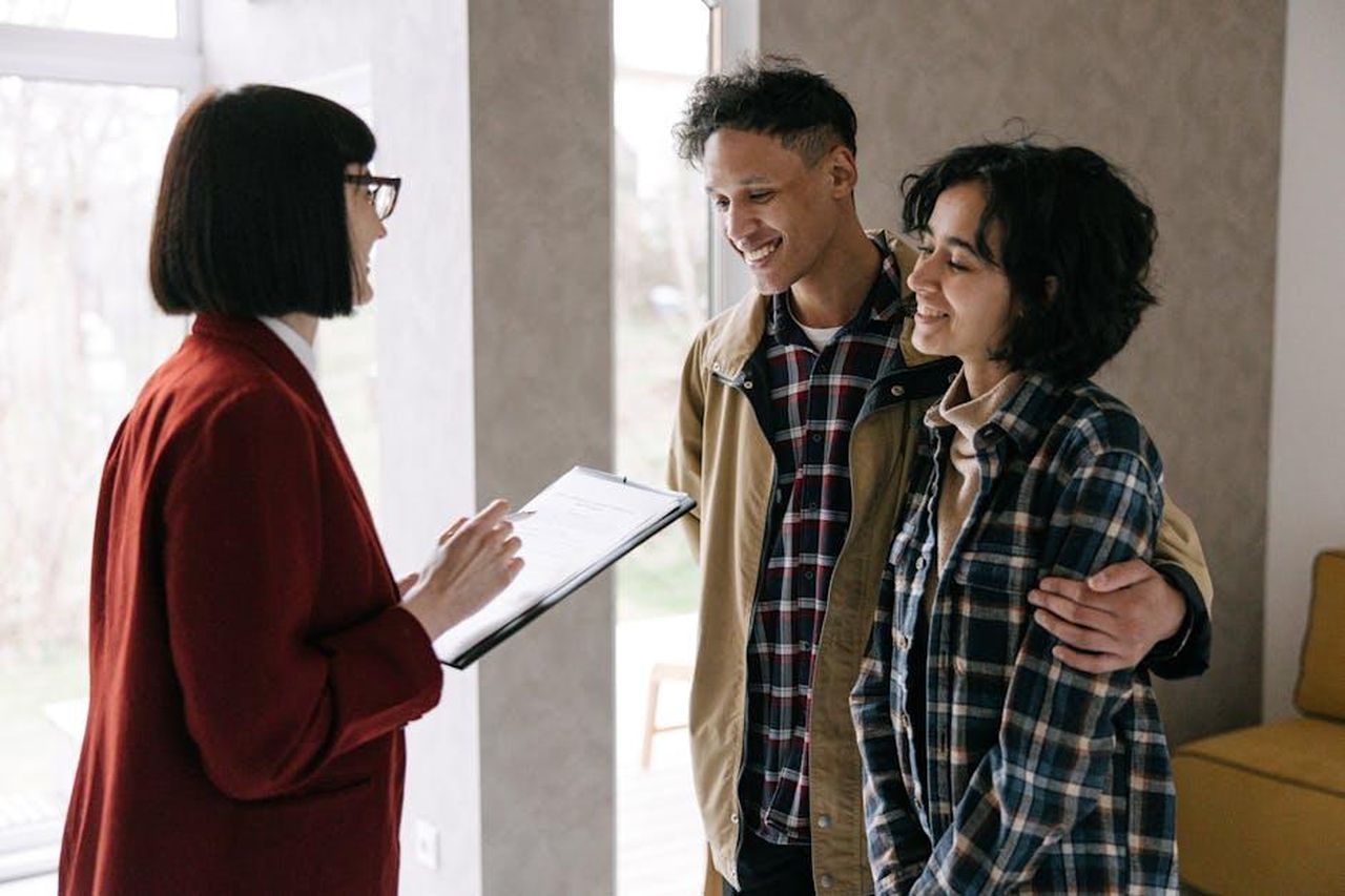 Target_Circle_Week_date_e_offerte_kCuQEJmitJ - Confidenze24 Source: Ivan Samkov - pexels - A young couple discusses housing options with a real estate agent inside a modern apartment.