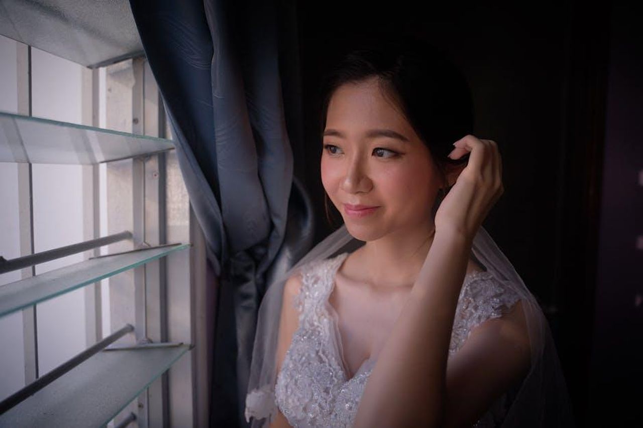 Taylor_e_Daniel_matrimonio_e_vita_dopo_Love_Is_Blind_rwaq7p6jVO - Confidenze24 Source: Loong Ken - pexels - A bride in a lace wedding dress gazes out a window, smiling softly.