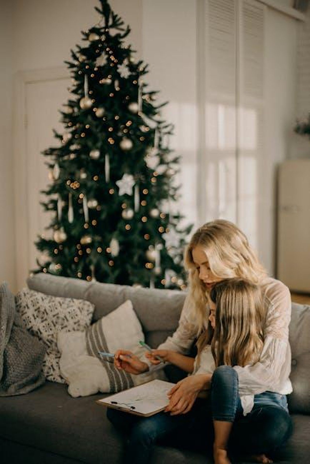 Tempo_di_qualit_BwBVTKwK4l - Confidenze24 Source: cottonbro studio - pexels - A mother and daughter enjoy a cozy moment by the Christmas tree indoors.