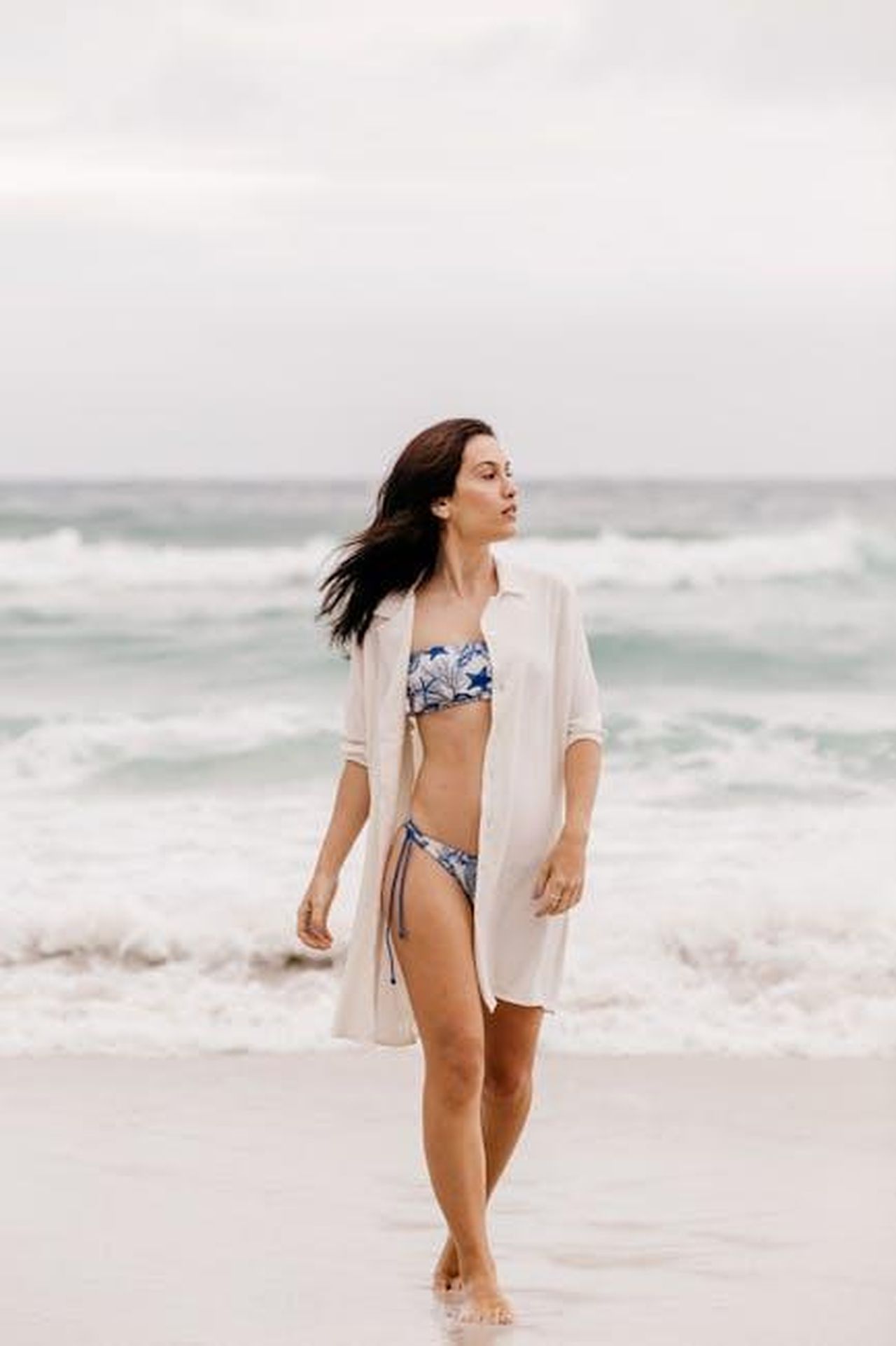 Teoria_4_Teddy_ha_aiutato_Nicola_a_coprire_il_crimine_W33lwK1FDi - Confidenze24 Source: Jonathan Borba - pexels - Woman in a bikini strolling along the sandy shore with waves in the background.