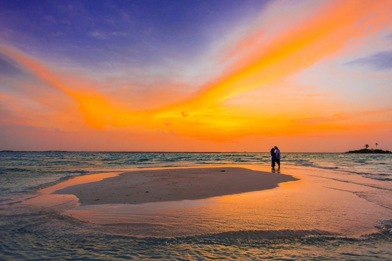 The_Honeymooners_19551956_WOT5YRSSEd - Confidenze24 Source: Asad Photo Maldives - pexels - Couple shares a romantic moment on a serene tropical beach at sunset, surrounded by vibrant colors.