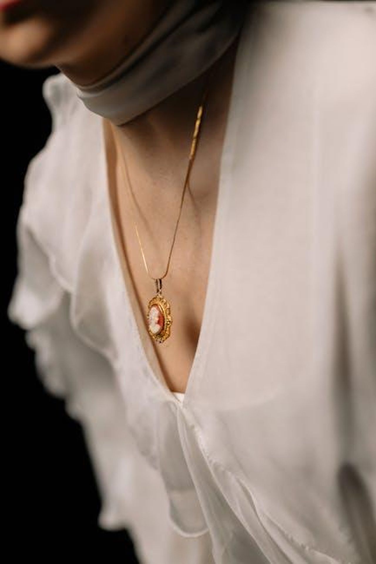 Tom_Selleck__Interessato_a_Fare_un_Cameo_2bhnnKSJrc - Confidenze24 Source: cottonbro studio - pexels - Close-up of a woman wearing a gold cameo necklace and white blouse, conveying elegance and sophistication.