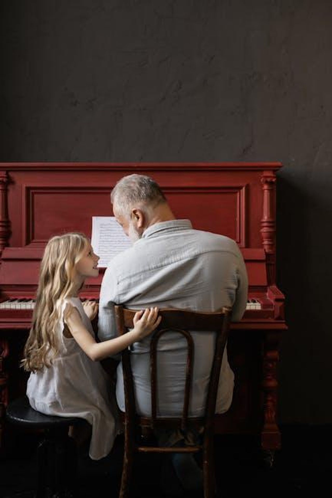 Tove_inizia_la_sua_educazione_musicale_7odwd0HsPG - Confidenze24 Source: Alena Darmel - pexels - A young girl and her grandfather enjoying a piano session, symbolizing family bonding and music learning.