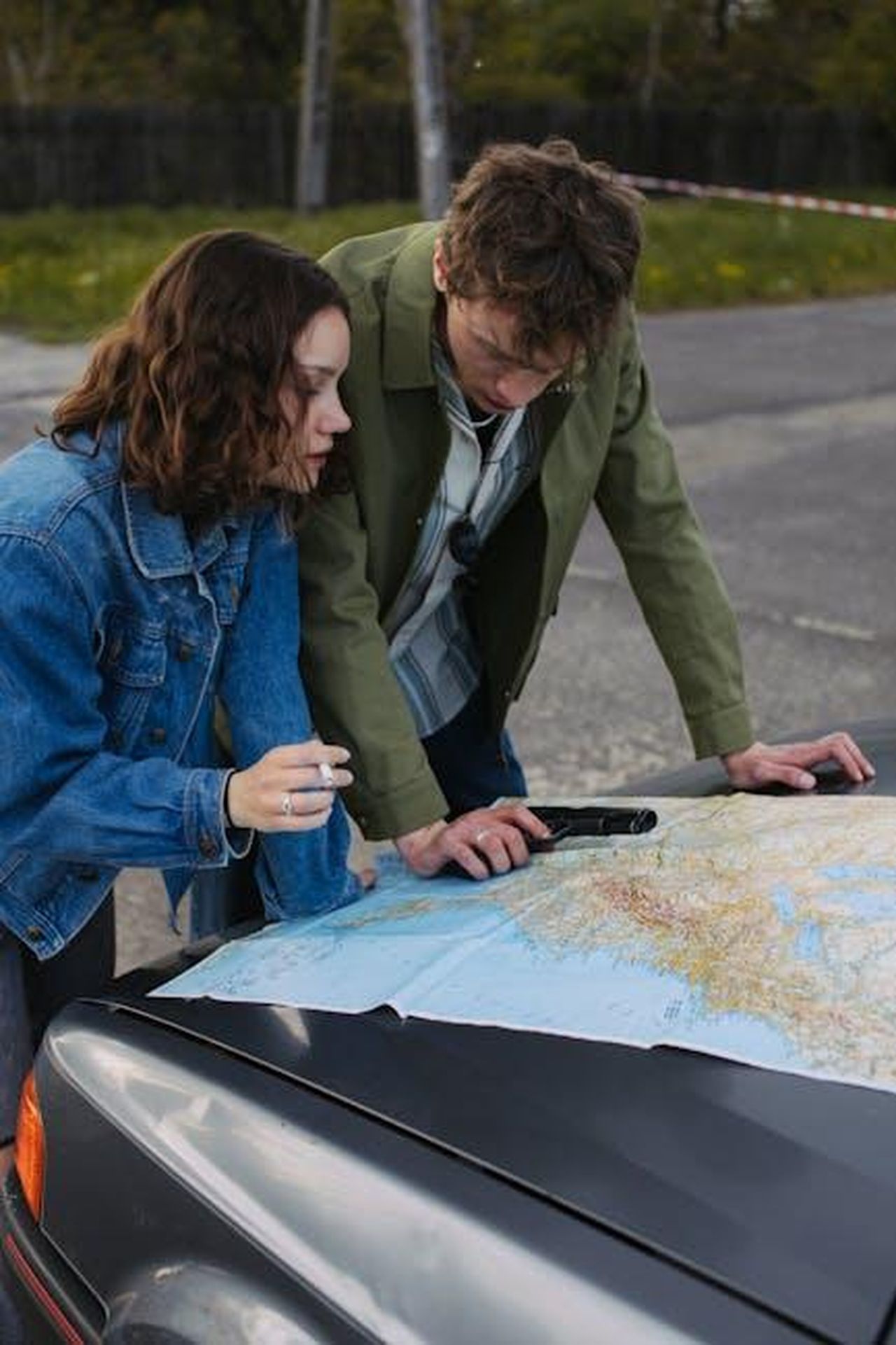Trama_di_The_Accountant_2_5mijemsBeB - Confidenze24 Source: KoolShooters - pexels - A young couple examines a map on a car hood, planning their next travel destination outdoors.
