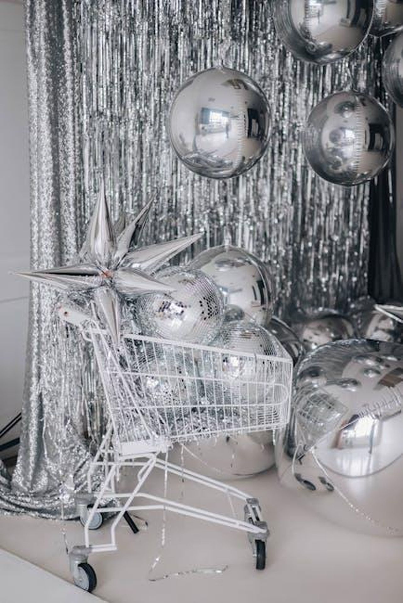 Tributo_affettuoso_al_calciatore_5J0qMqKbFP - Confidenze24 Source: Valeria Boltneva - pexels - A festive scene with silver balloons and a shopping cart against a shiny backdrop, perfect for celebrations.