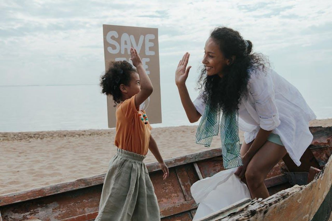 Tutto_su_Emily_Baldoni_tLNxrjNqLR - Confidenze24 Source: Ron Lach - pexels - Mother and child high-five during a fun beach cleanup with a save the planet sign.