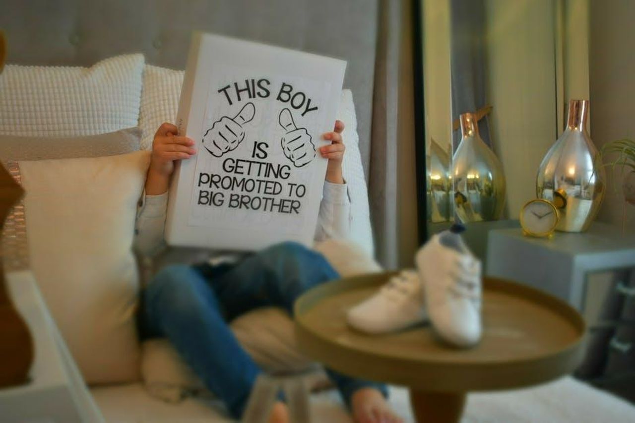 Ultime_su_Celebrity_Big_Brother_67xvqrrlgN - Confidenze24 Source: Yama Saighani - pexels - Child holding a sign in welcoming interior space, celebrating becoming a big brother.