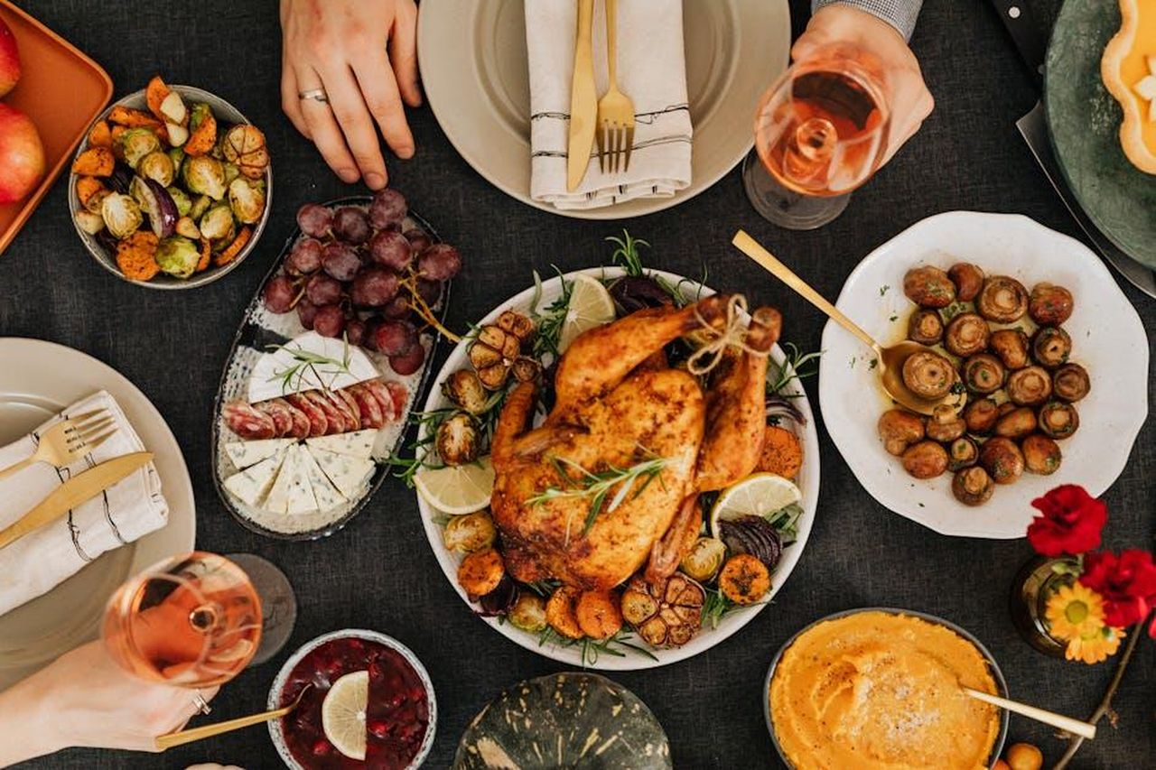 Un_piatto_adatto_per_le_festivit_QqA5KPCzi6 - Confidenze24 Source: Photo By: Kaboompics.com - pexels - Top-down view of a delicious roast chicken dinner surrounded by sides on a festive table.