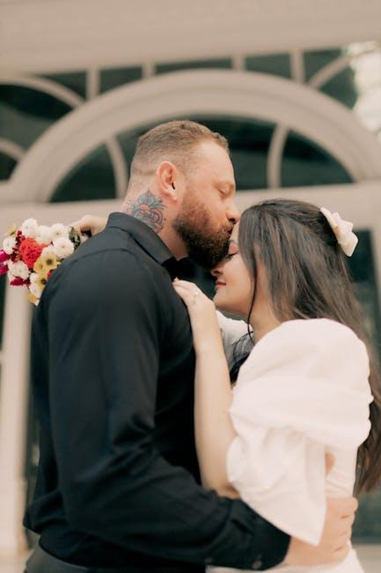 Una_matrimonio_difficile_hdwokqTWEx - Confidenze24 Source: Alexander Mass - pexels - A loving couple shares a tender moment, embracing with flowers.