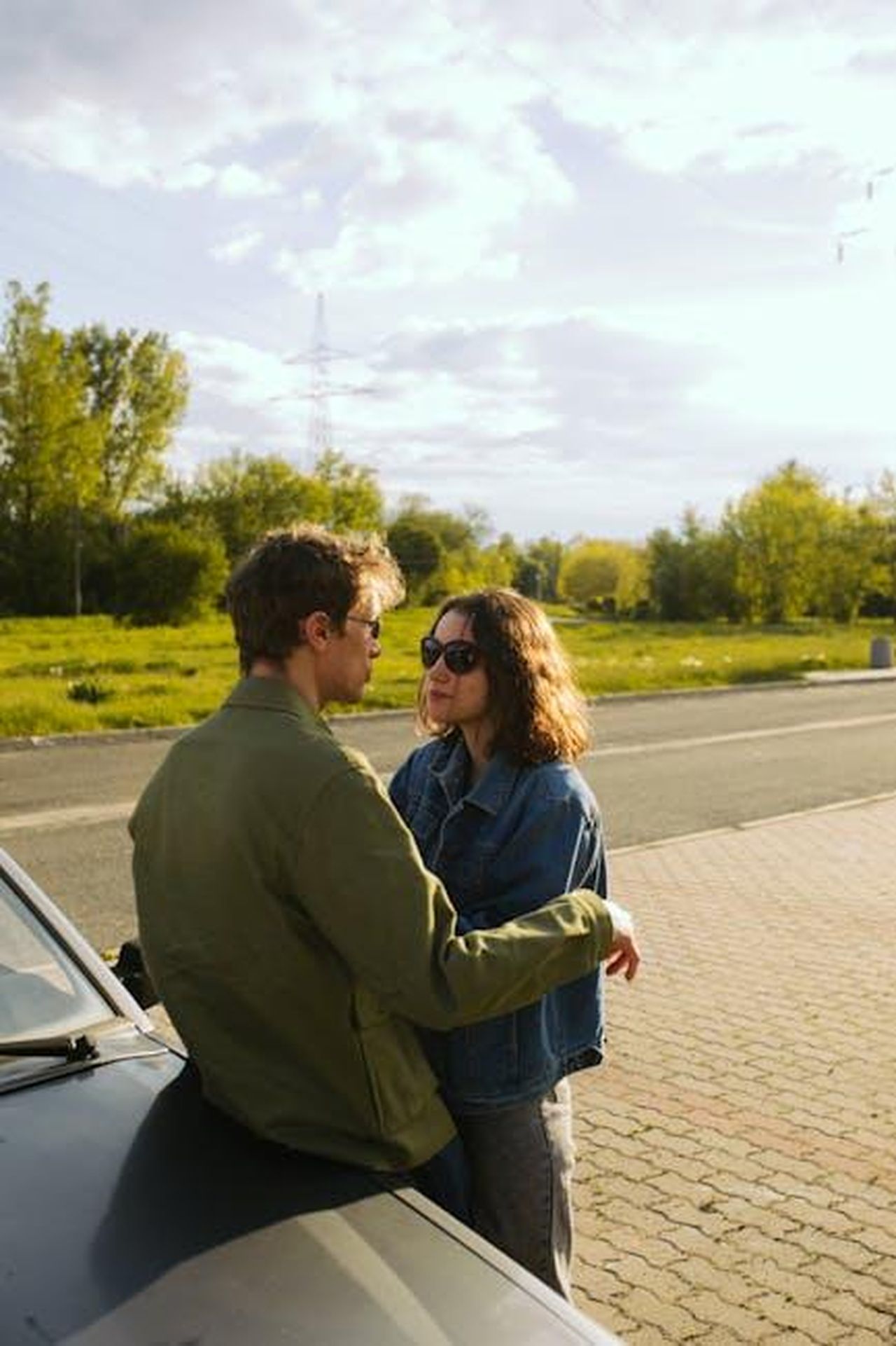 Unavventura_di_furto_e_intrigo_gharVwHdrT - Confidenze24 Source: KoolShooters - pexels - Young couple outdoors, leaning on a car, embracing and enjoying a sunny day.