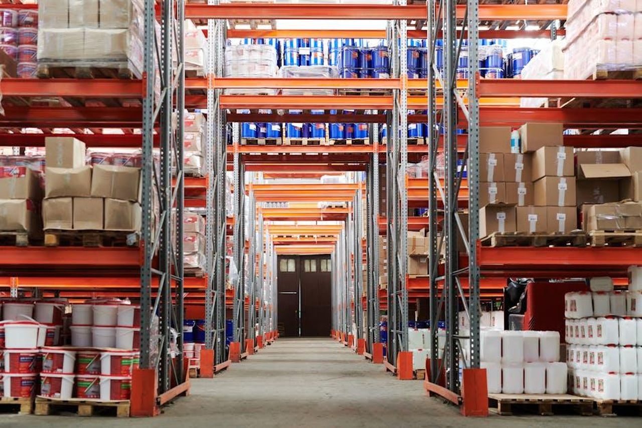 Utilizzi_Alternativi_del_Carrello_di_Stoccaggio_KKrsC9BcvW - Confidenze24 Source: Tiger Lily - pexels - Wide angle view of a warehouse with stocked shelves and boxes.