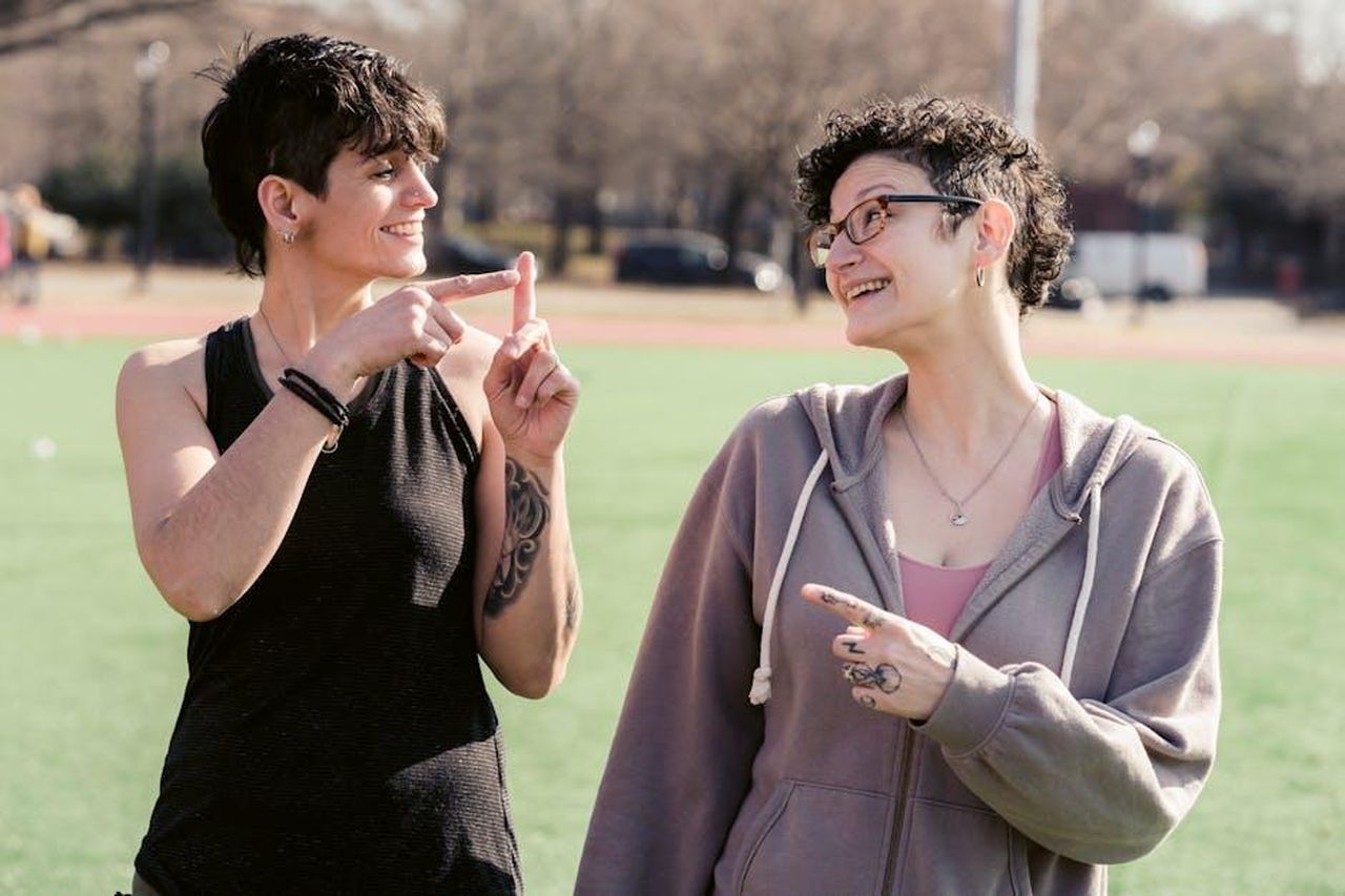 Vanessa_Feltz_sul_suo_nuovo_show_uUVmgc8Ymw - Confidenze24 Source: Sarah Chai - pexels - Two women sharing a joyful moment outdoors, pointing at each other playfully.