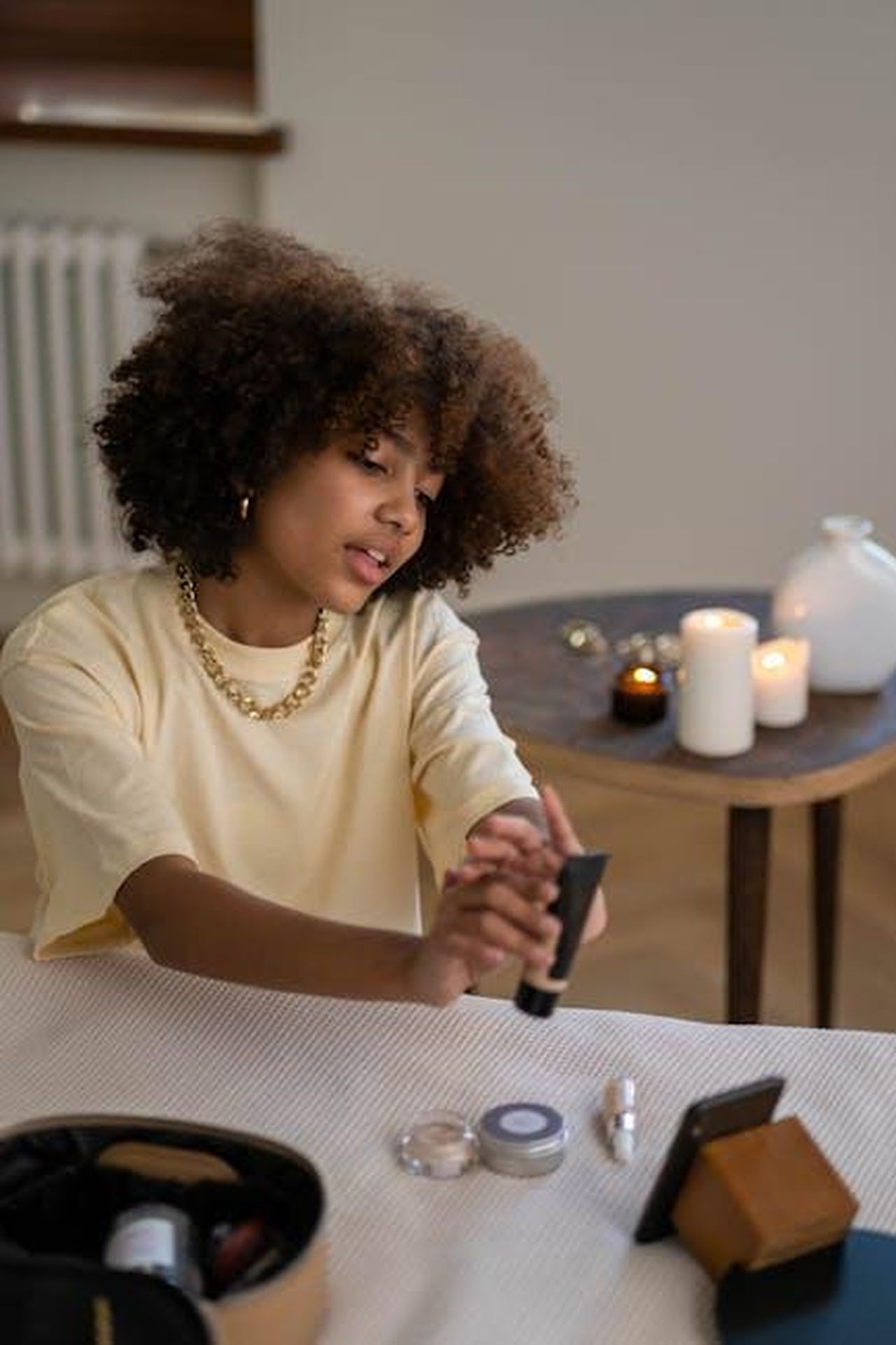 Vantaggi_del_Beauty_Balm_recensioni_entusiaste_zPoXNBbZzx - Confidenze24 Source: Ron Lach - pexels - A young beauty influencer reviews skincare products in a cozy indoor setting with candles.