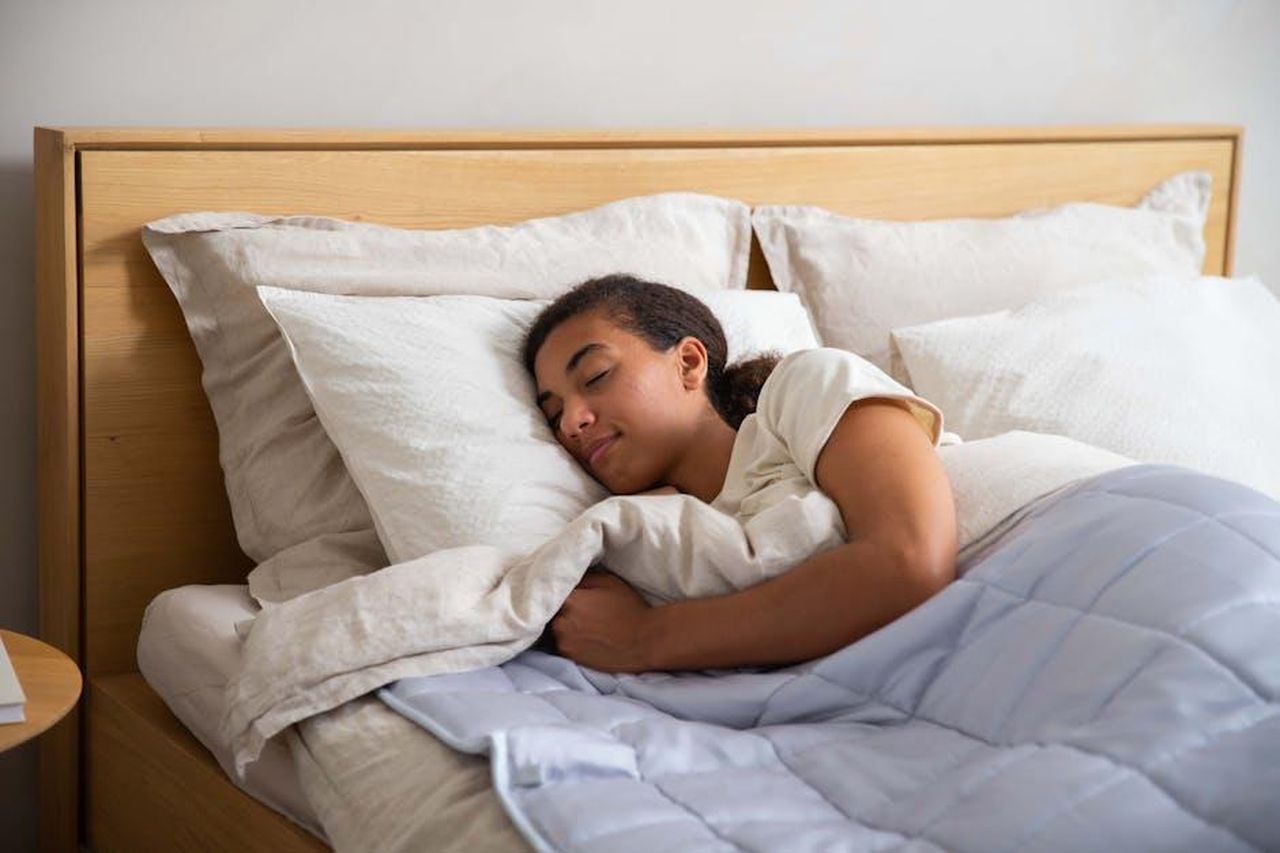 Vantaggi_del_Hatch_Restore_3_U9umSYkACg - Confidenze24 Source: Niels from Slaapwijsheid.nl - pexels - Adult resting under a cozy duvet in a serene bedroom setting promoting relaxation and wellness.