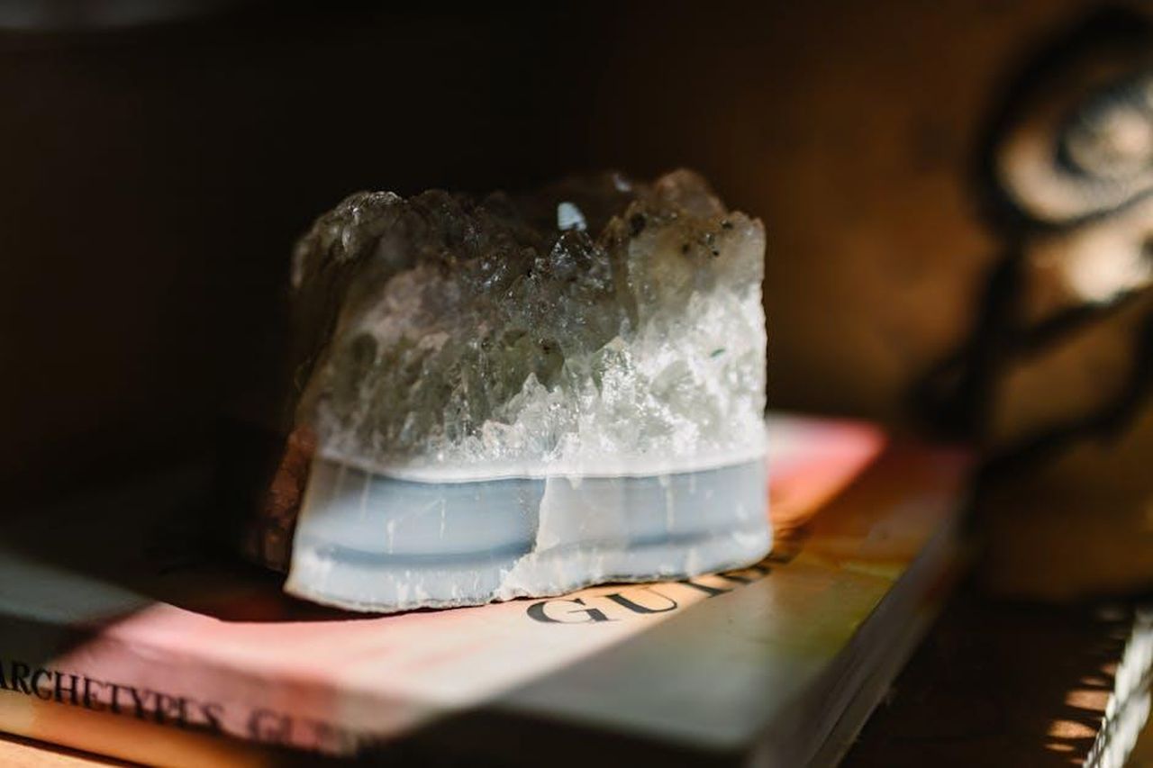 Vergine_23_Agosto__22_Settembre_LD8s3sqO7i - Confidenze24 Source: RDNE Stock project - pexels - A beautiful crystal stone resting on a book, illuminated by soft sunlight, creating a serene atmosphere.