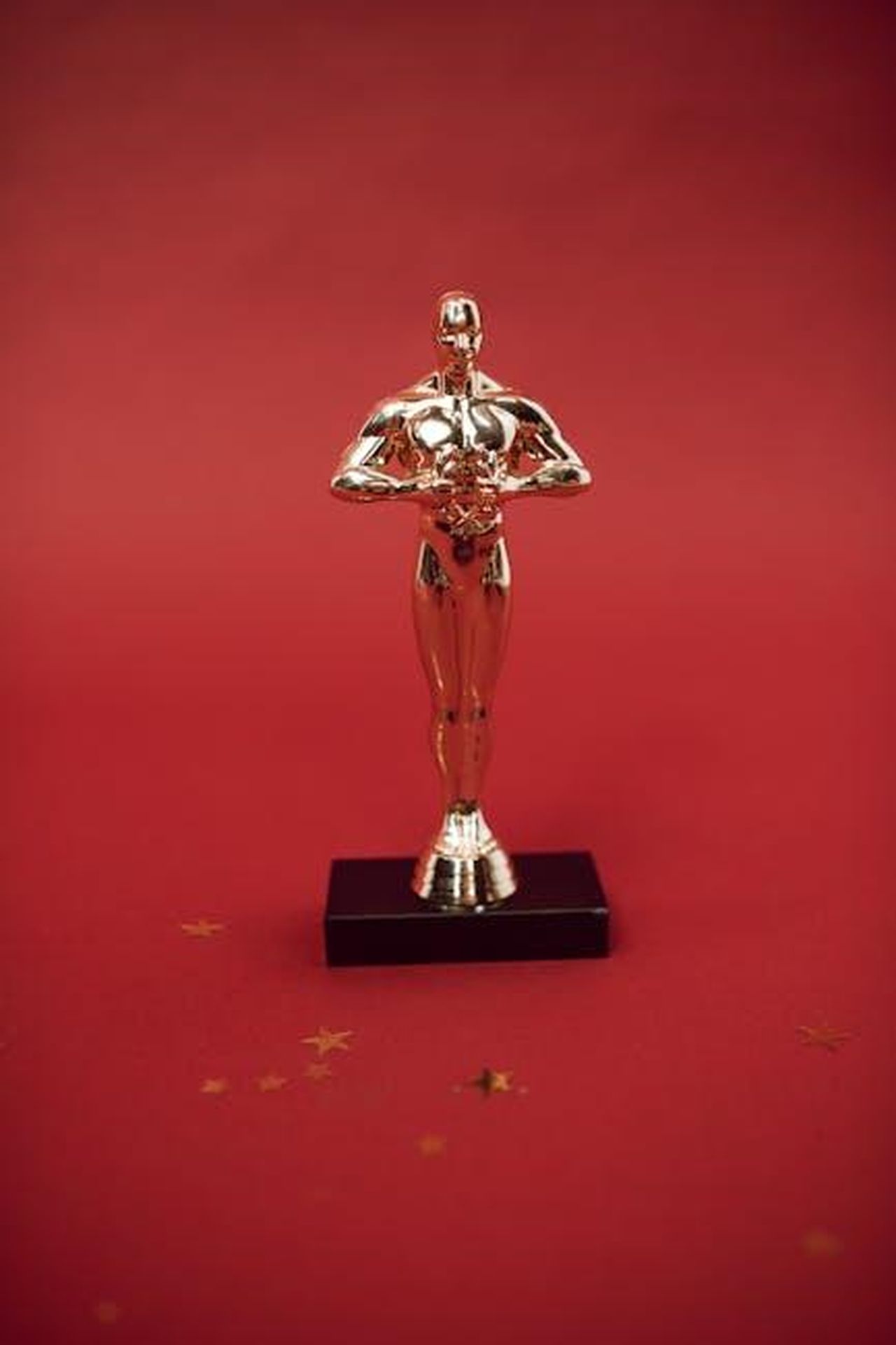 Vincitori_degli_Oscar_2025_tpCWCIkAB7 - Confidenze24 Source: RDNE Stock project - pexels - A shiny golden trophy standing against a vivid red backdrop, symbolizing achievement.