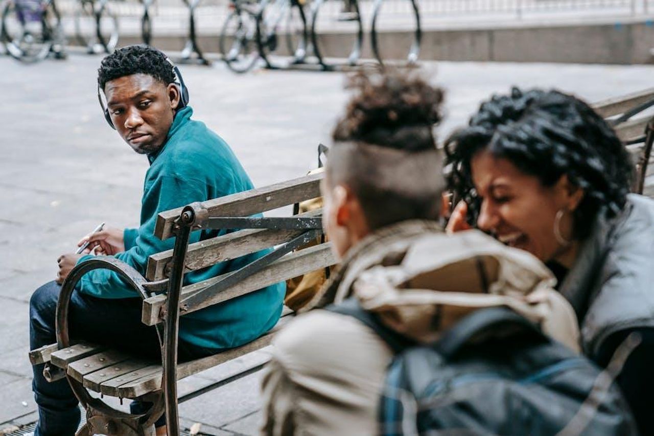 Voci_false_sulla_sua_vita_amorosa_yOGWNKKZ7R - Confidenze24 Source: Keira Burton - pexels - A diverse group of young adults engage in conversation on a street bench.
