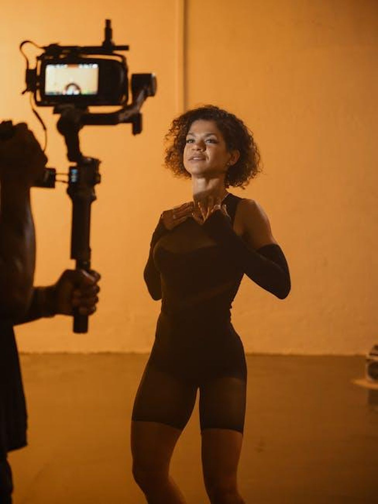 West_Duchovny_la_carriera_in_ascesa_xckhJCfCT6 - Confidenze24 Source: Jaycee300s - pexels - Young woman poses in a film studio with professional camera. Warm lighting.
