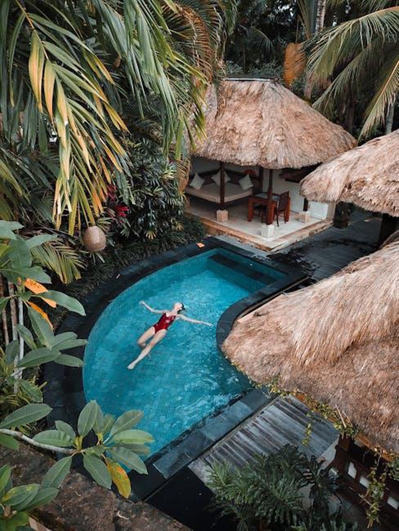 William_e_la_sua_famiglia_al_Villa_Park_y61bZlM3gb - Confidenze24 Source: Michael Block - pexels - A woman enjoying leisure time floating in a tropical resort pool surrounded by lush greenery.