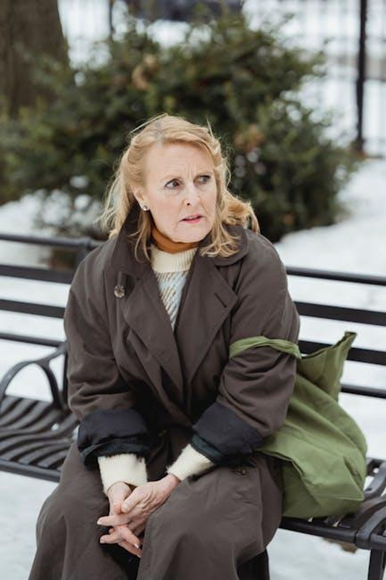_un_commento_appropriato_da_fare_vaaWlE5Ka6 - Confidenze24 Source: Teona Swift - pexels - Elderly woman in warm coat sits on a park bench, looking anxious in winter setting.