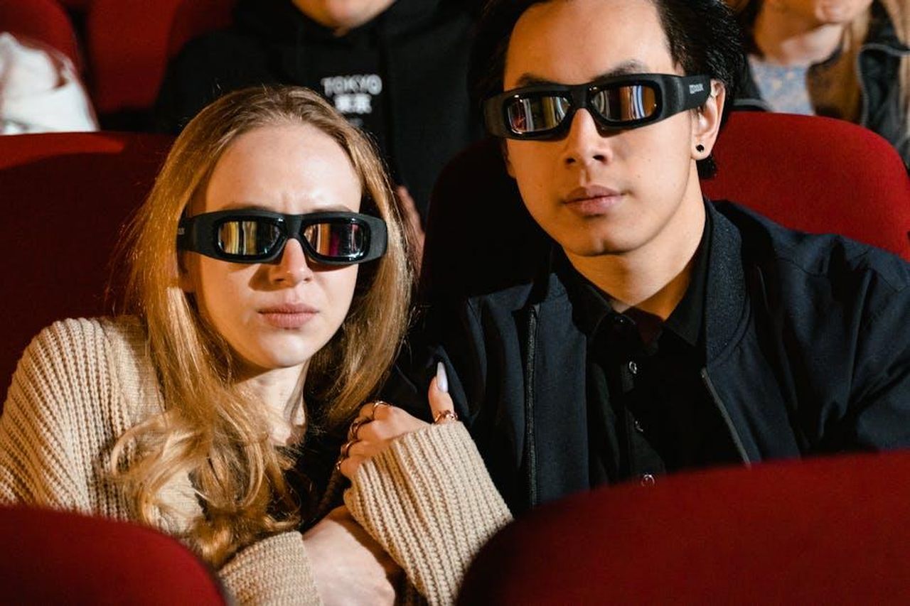 Commenti_dei_telespettatori_hXEu99RqLC - Confidenze24 Source: Tima Miroshnichenko - pexels - A couple watching a 3D movie together, wearing 3D glasses in a cozy cinema setting.