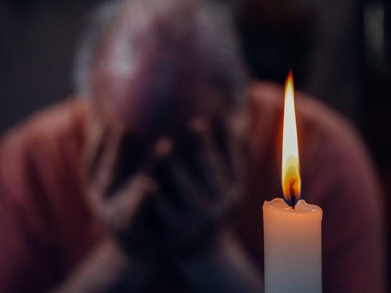 Cosa_ha_detto_Ruth_Langsford_sulla_demenza_7o1UQhfEdx - Confidenze24 Source: Kindel Media - pexels - A senior adult in an emotional moment lit by a candle, symbolizing reflection and grief.