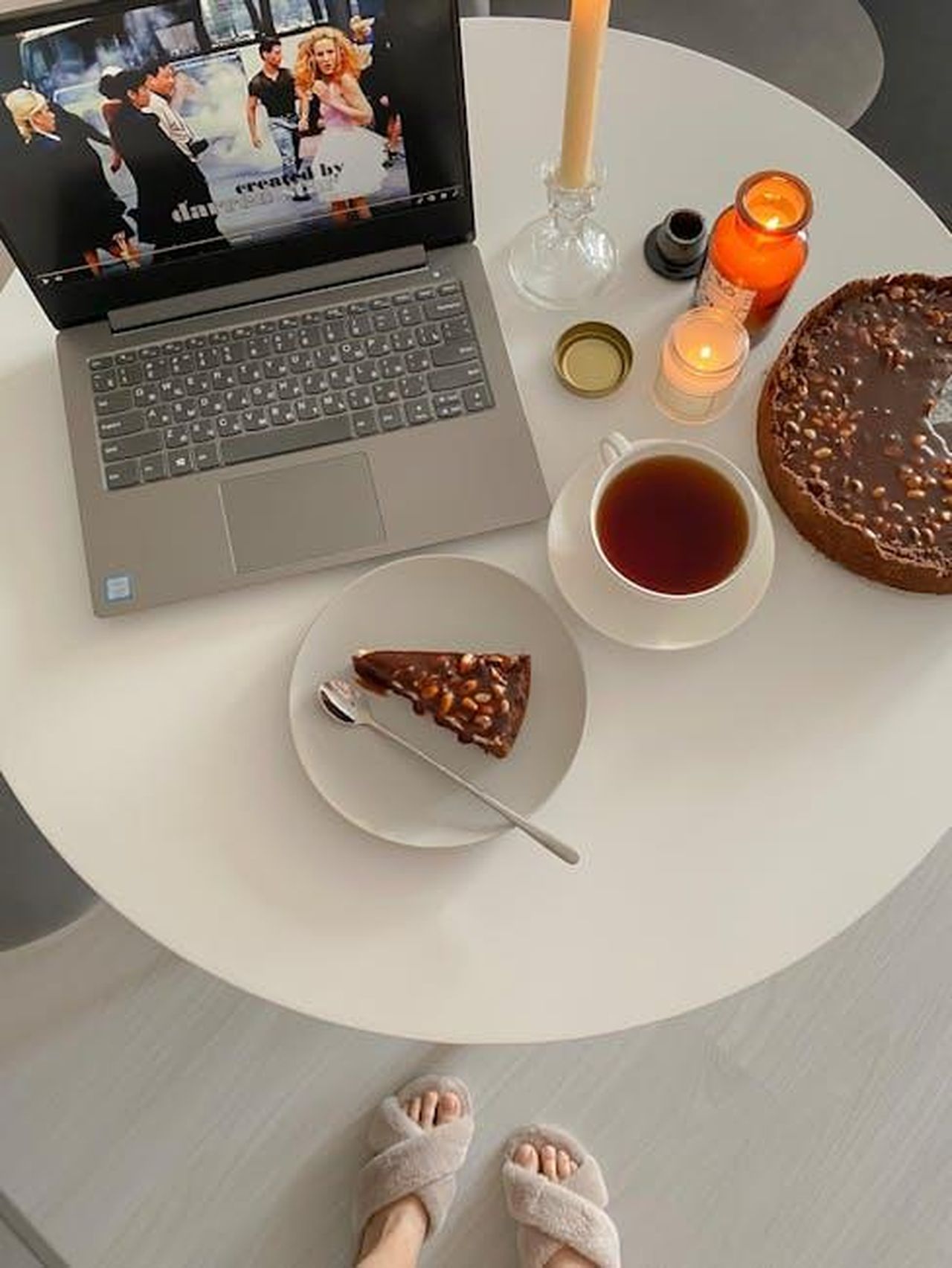 I_fan_si_infuriano_per_la_ripetizione_di_Chi_vuole_essere_milionario_QLJ2m1lXcR - Confidenze24 Source: Анастасия - pexels - A cozy indoor scene featuring a slice of cake, cup of tea, and laptop on a round table.