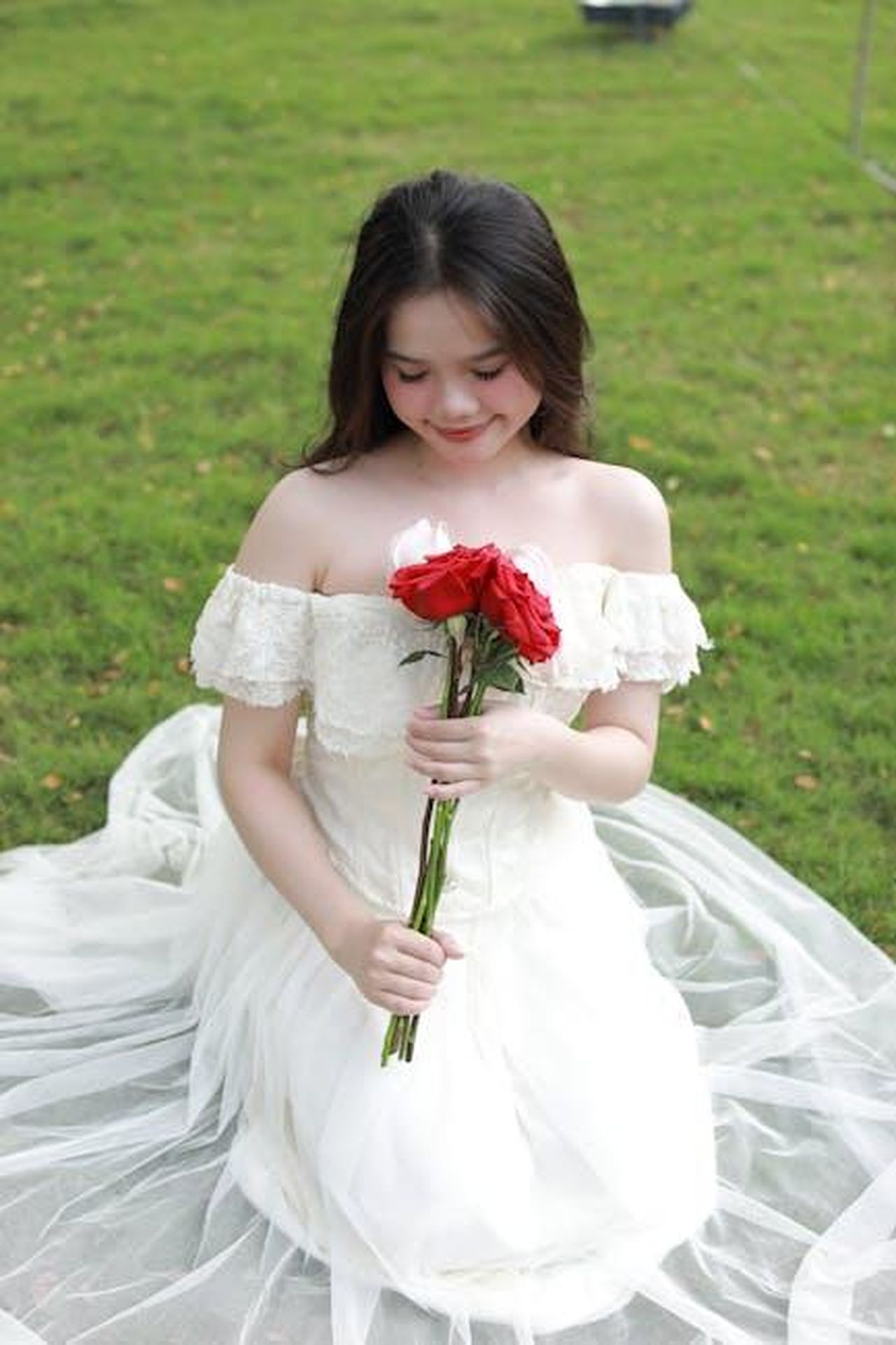 Il_matrimonio_di_Amy_con_un_ex_coprotagonista_OQ2yudkfcU - Confidenze24 Source: Ngô Hoàng Canon - pexels - A young bride in a white dress sitting on grass, holding red roses.