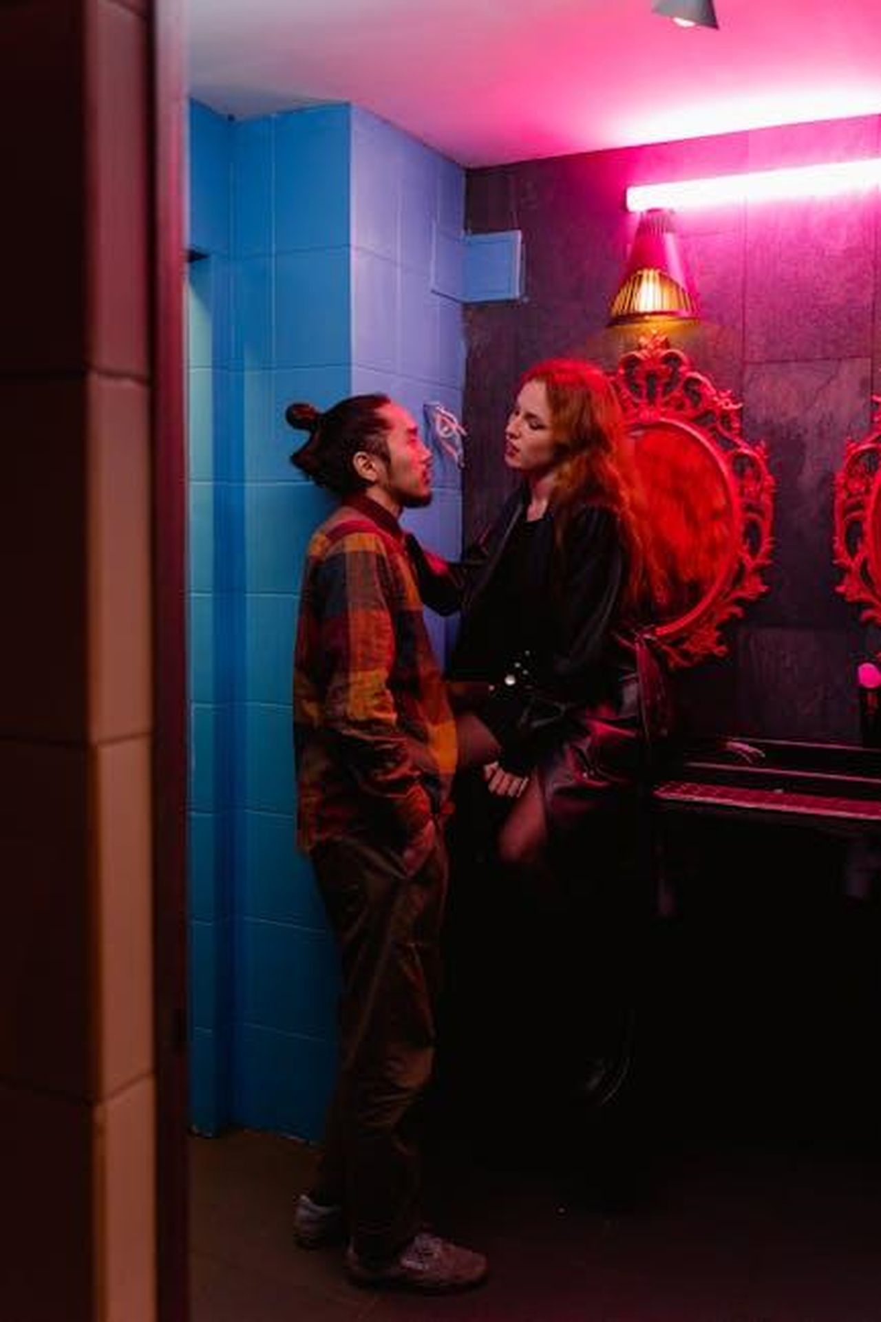 Il_passato_di_Anderson_Paak_e_la_sua_nuova_relazione_m0aJzae8dB - Confidenze24 Source: MART PRODUCTION - pexels - A stylish couple shares a moment in a neon-lit restroom, creating a vibrant nightlife scene.