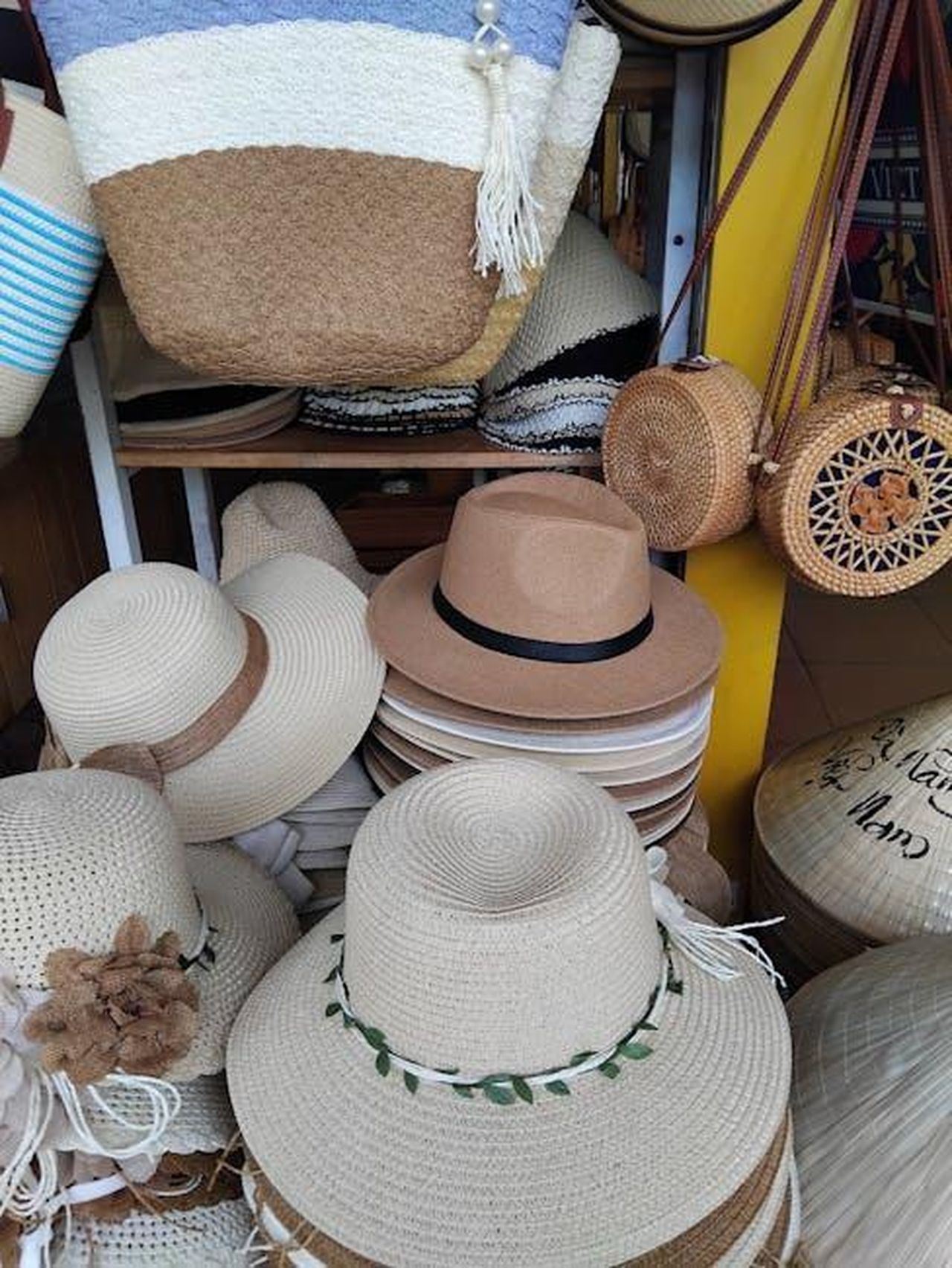 Implicazioni_per_il_mercato_della_moda_n55gr4gJlD - Confidenze24 Source: Pornsiri Thetchutithamgull - pexels - A variety of straw and woven hats on display at an outdoor market, showcasing diverse designs and textures.