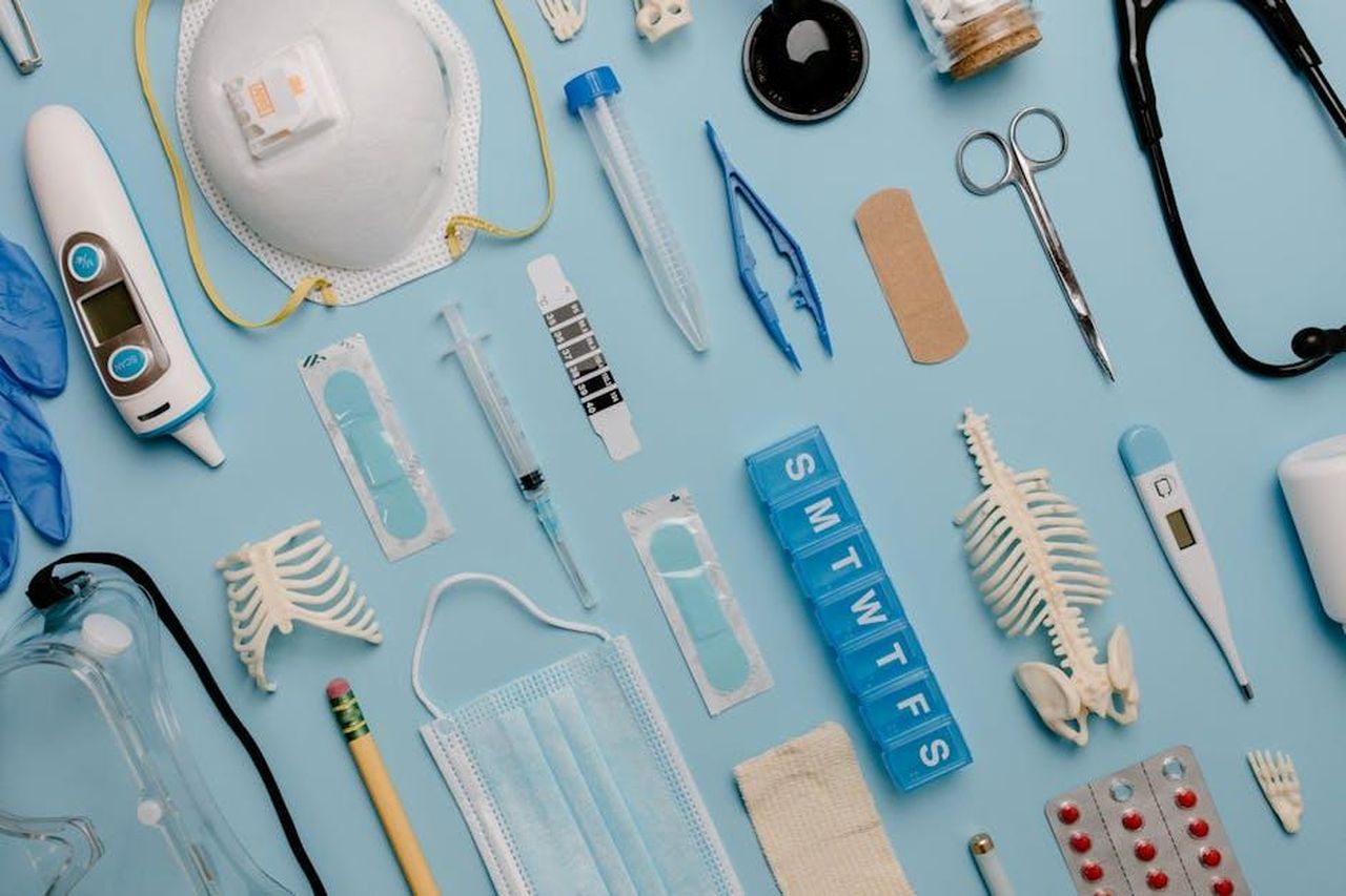 La_chimica_tra_i_due_attori_sul_set_W4necGqGdO - Confidenze24 Source: Tara Winstead - pexels - A comprehensive flat lay of diverse medical supplies including PPE and diagnostic equipment on a blue surface.
